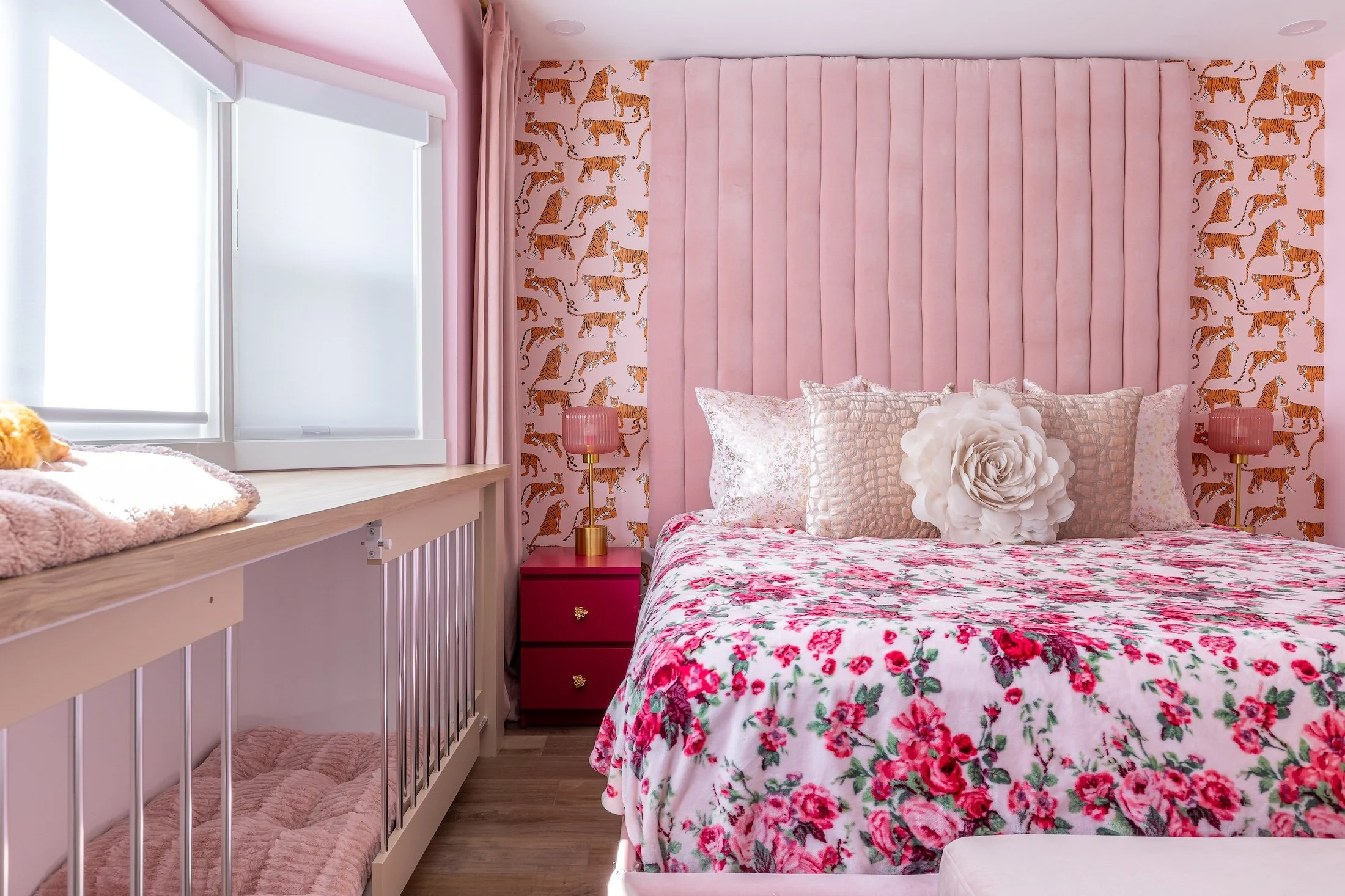 an all pink room is shown featuring a custom channel tufted headboard, custom pink pillows, and a custom dog crate for a bay window