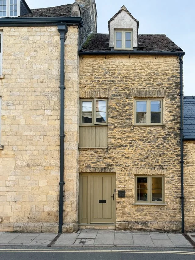 A stone brick house with pale green door and window.