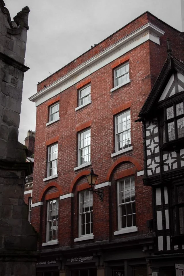 A red brick Georgian style block of flats in a city centre.