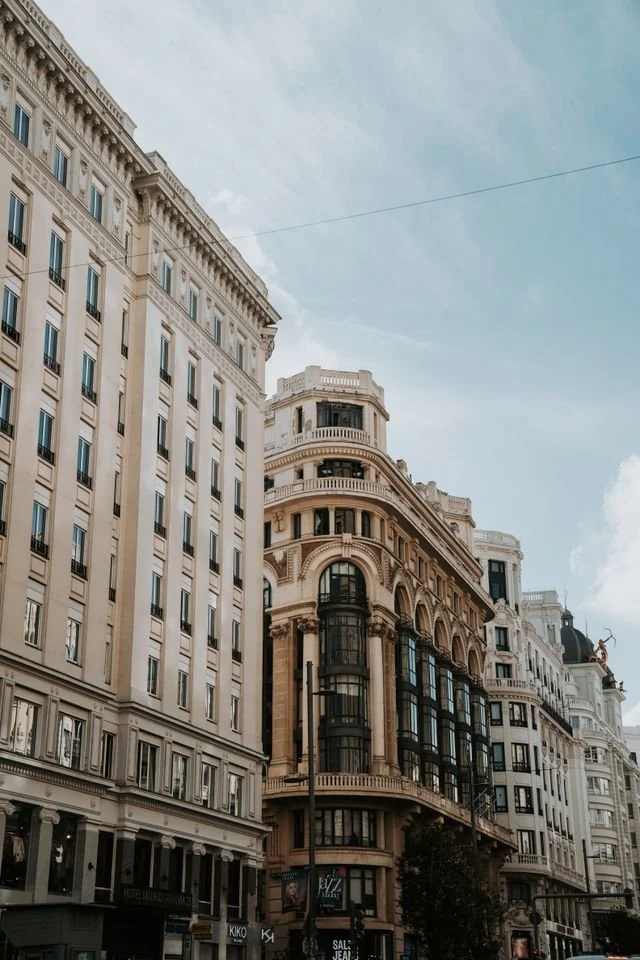 Tall, historic buildings with ornate facades in the City of London financial district.