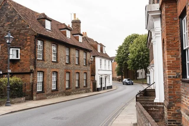 A quiet street lined with old brick terraced houses.