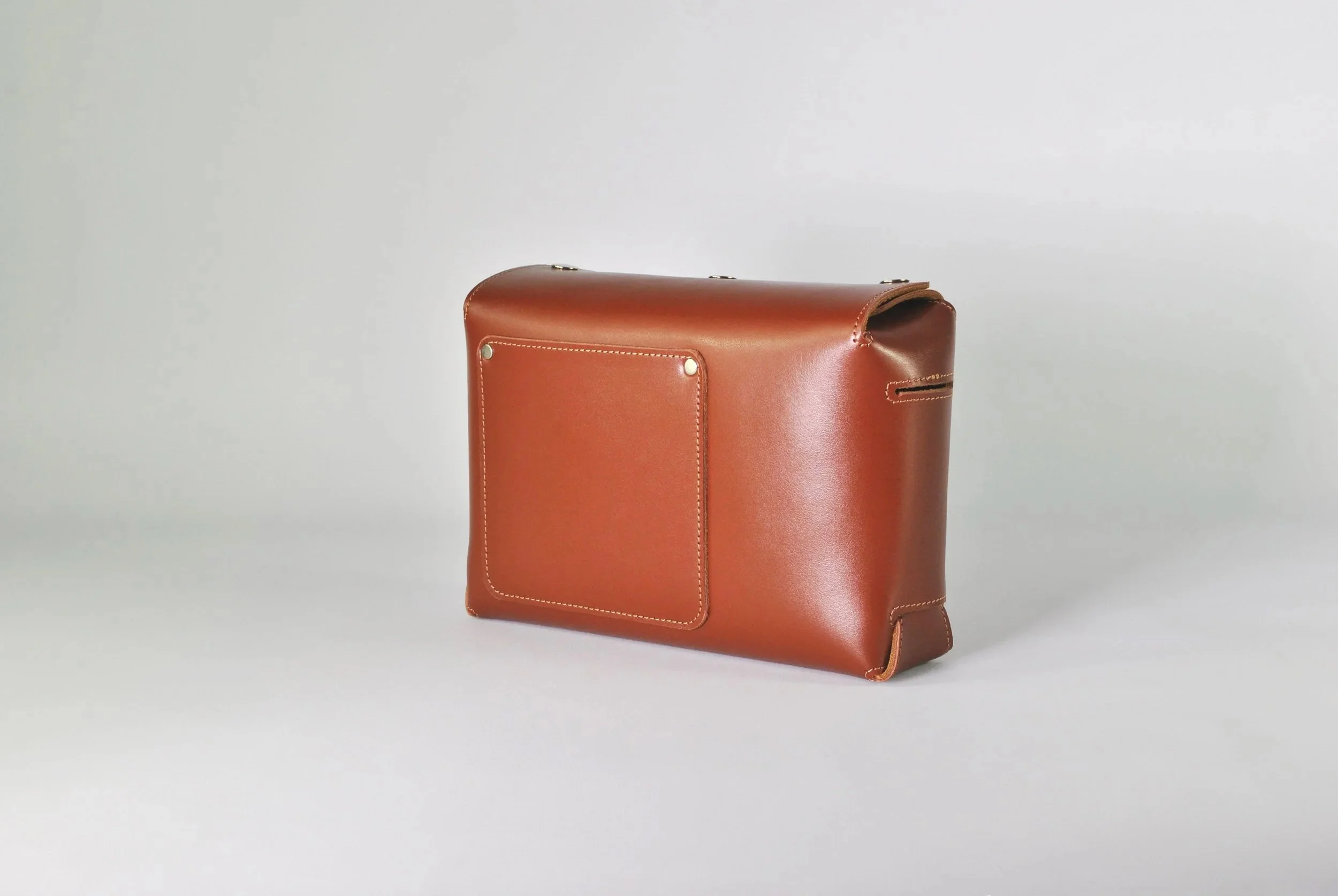 Brown leather briefcase on a plain neutral background
