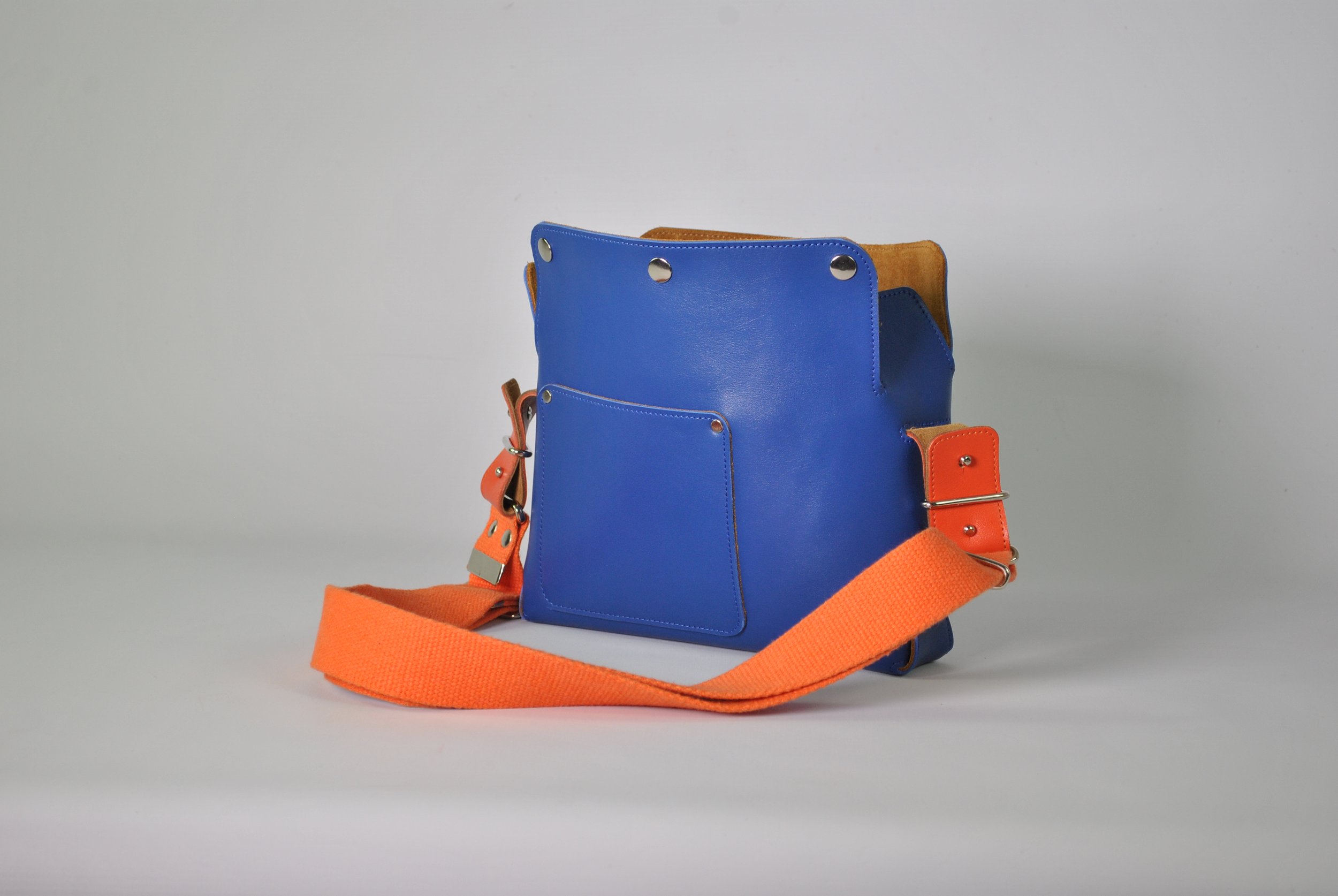 Colorful handbag with a blue main body, orange strap, and orange accents on the sides and hardware.