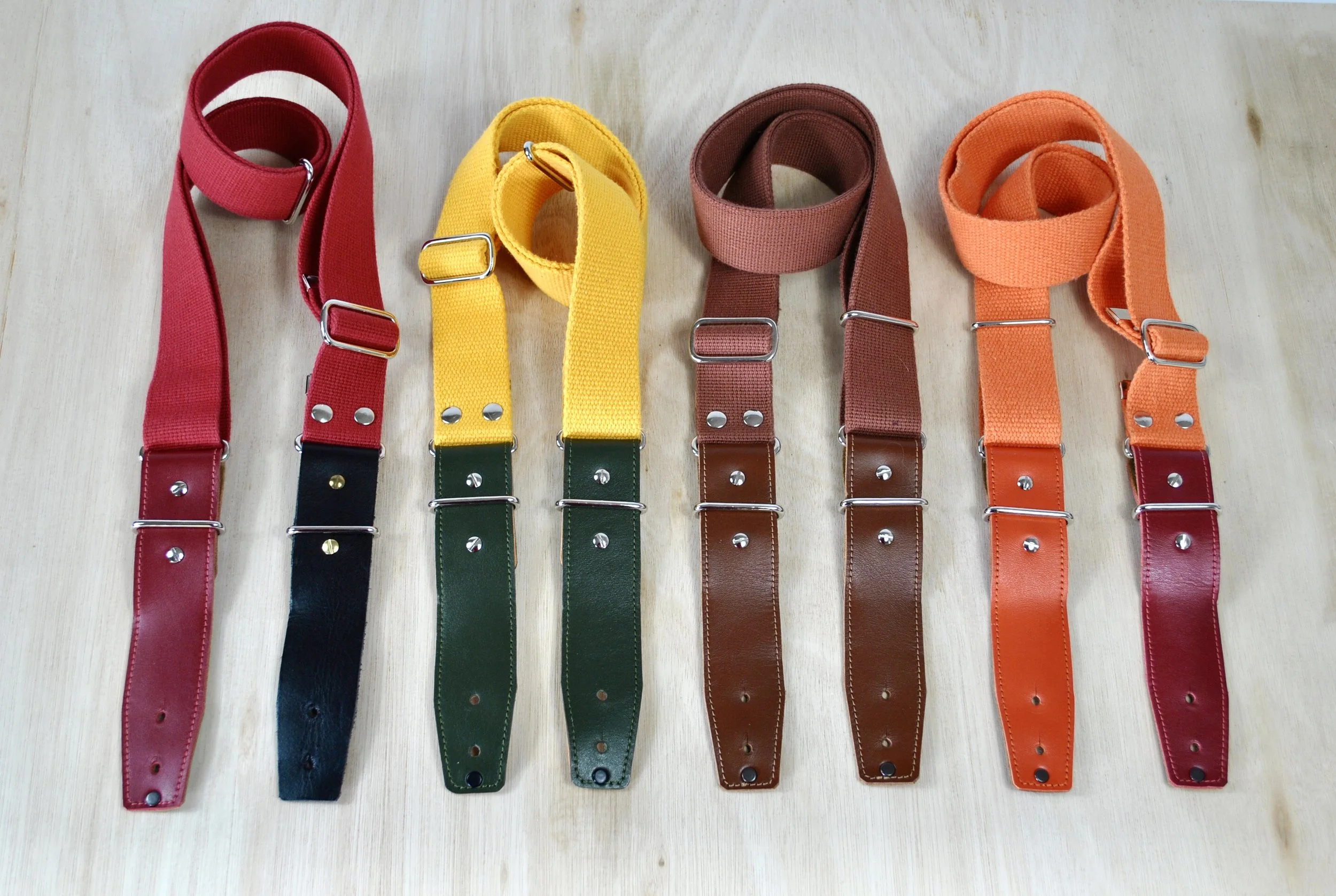 A collection of colourful cotton straps with different coloured connectors, with silver metal hardware.