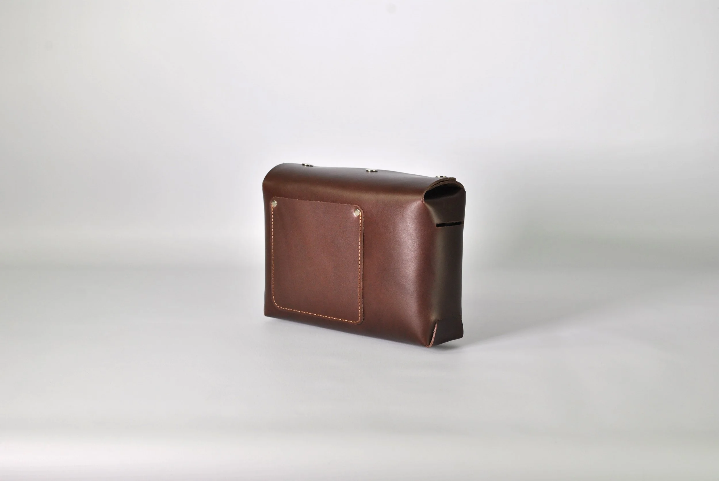 Brown leather briefcase with a front pocket, set against a plain white background.