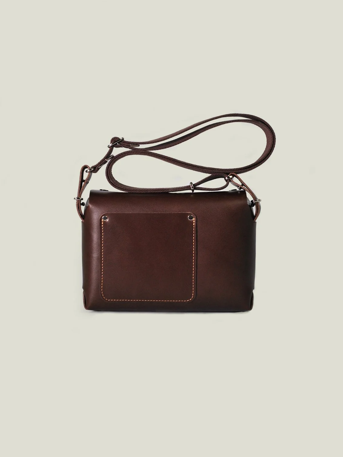 Dark brown leather shoulder bag with a front pocket and adjustable strap, isolated on a light background.
