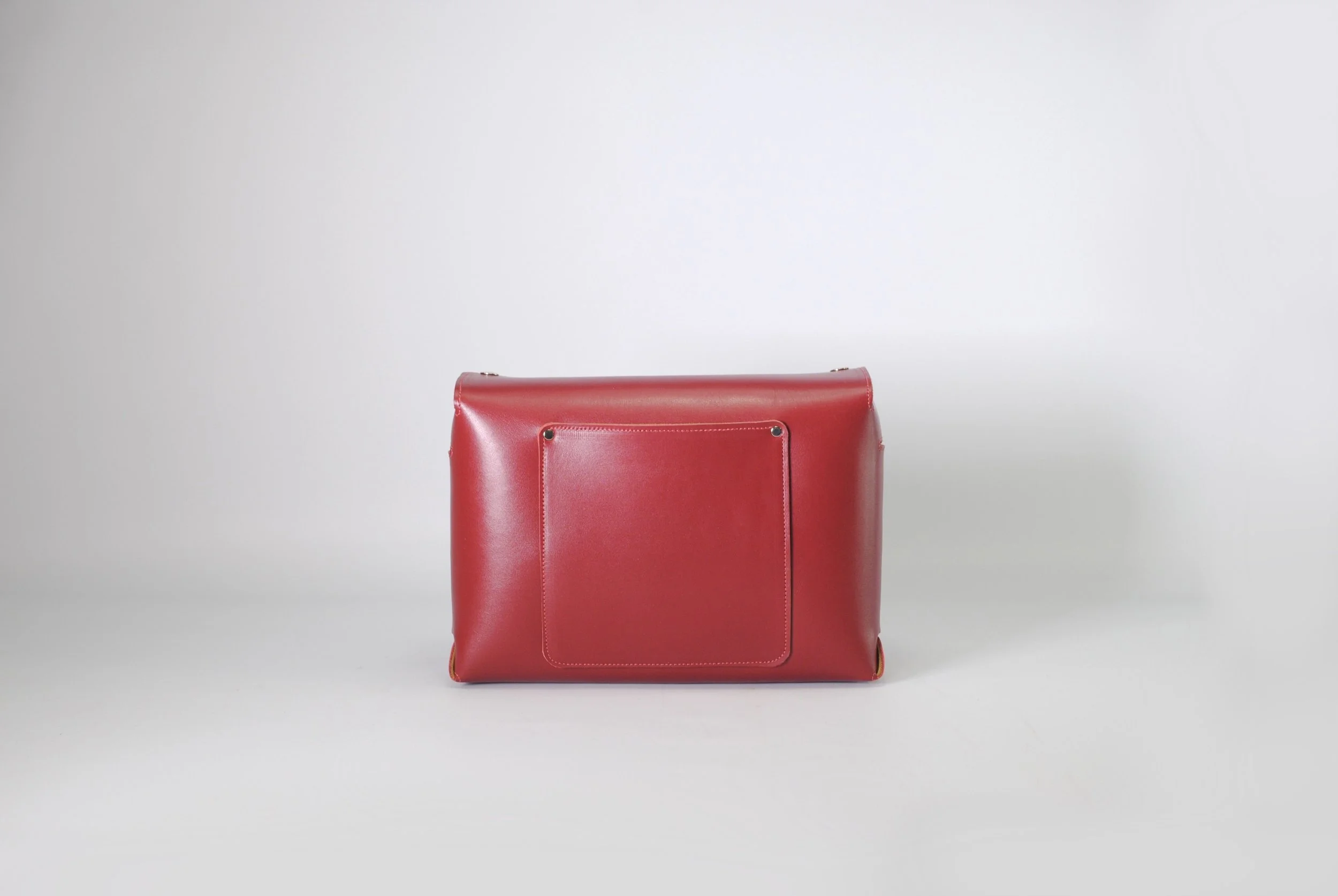 Red leather handbag against a plain white background.