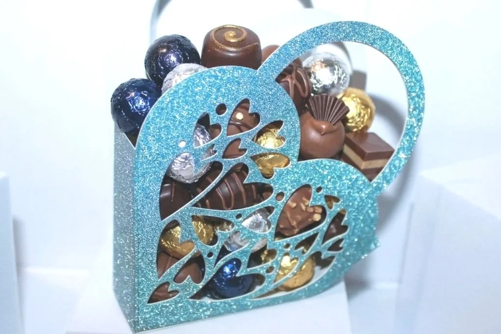 Intricate heart box with handles! 
Crafted from a beautiful blue glitter card, 

this box has been intricately cut with inner hearts & a background colour to highlight the hearts. #0072

