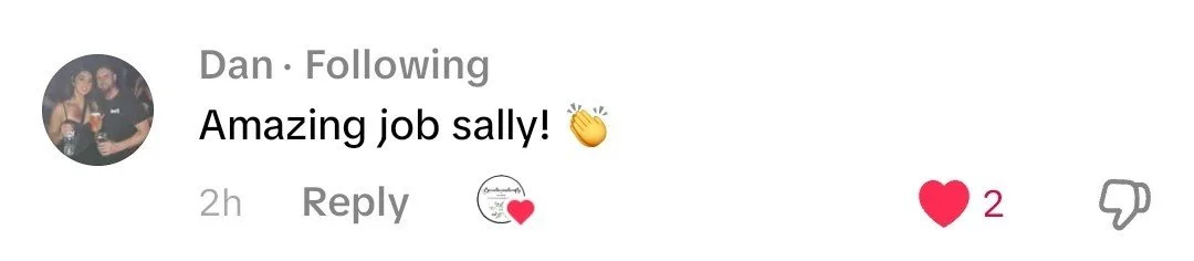 Comment section of a social media post with a comment saying "Amazing job sally!" and a clapping hands emoji, with two hearts below indicating likes.