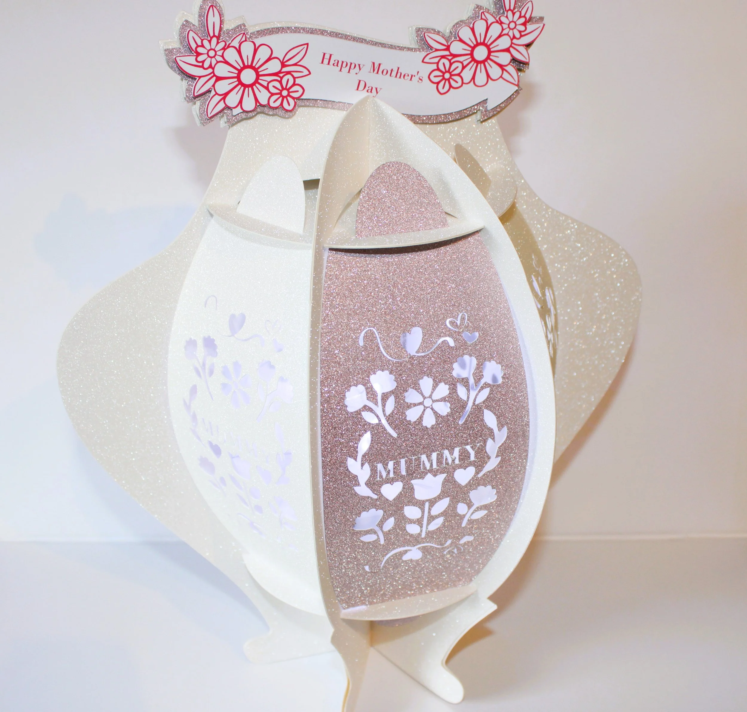(NEW) Mother's Day Lantern! 
Each panel features delicate floral cut-outs and the word “MUMMY” elegantly die-cut into the sides, with clear acetate windows behind the designs to create a soft, glowing effect. #00230