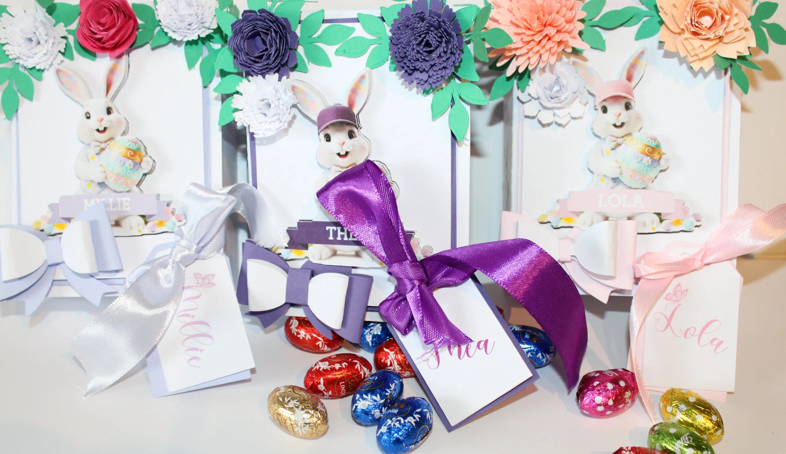 Open the boxes to reveal tissue-paper-lined interiors, thoughtfully arranged and filled with mini chocolate eggs. The spines are inscribed with "Happy Easter" alongside the recipient’s name, creating a keepsake-ready presentation that doubles as seas