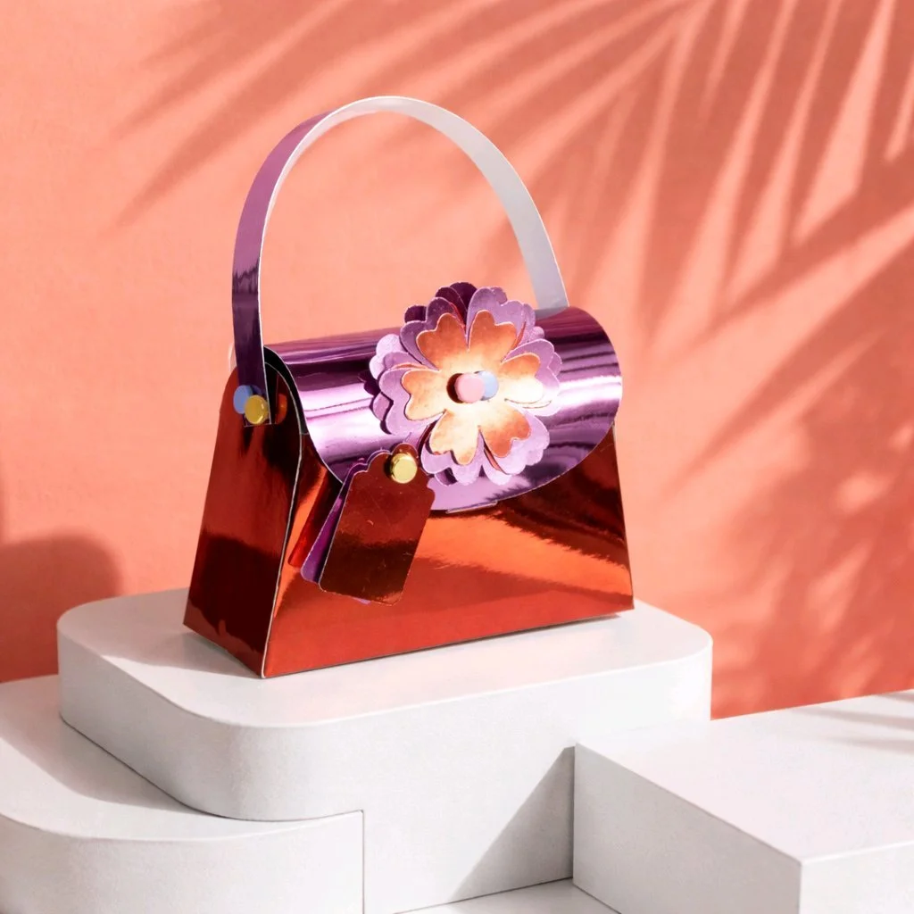 Personalised Gift Bag! 
Handbag gift box cut from sturdy holographic cardstock finished with a holographic flower on the front and an attached matching gift tag.  Perfect for small presents, jewellery or gift card inserts. #00602
