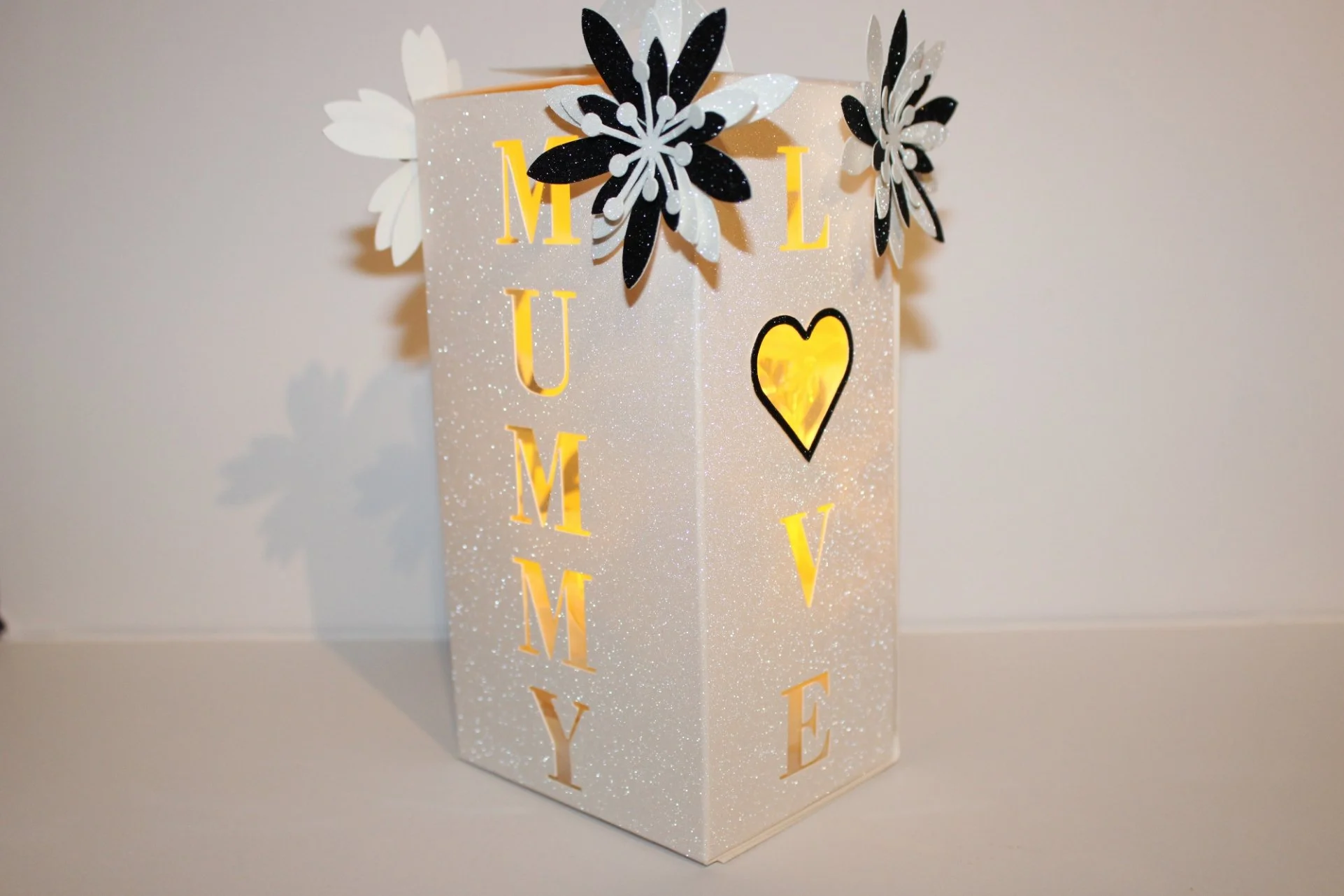 The fourth panel displays a beautifully cut floral motif that complements the wording on the other sides. A neat tuck-style closing is attached to the lid for secure, elegant presentation. 