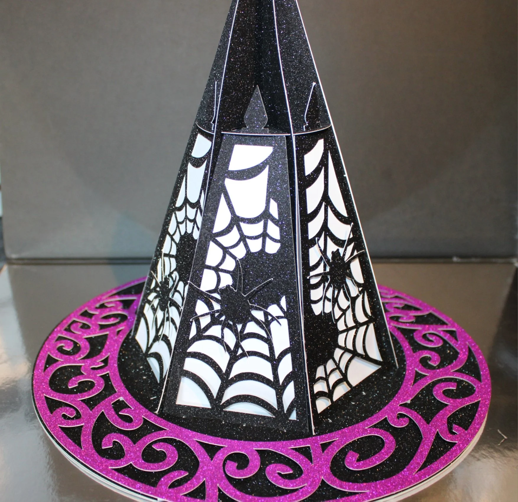 Halloween Hat Lantern With LED Lights Inside!
A bewitching centrepiece for Halloween or themed décor, this witches’ hat lantern is cut entirely from sturdy card and finished with haunted detailing for a spookily elegant look.
Designed to hold shape a