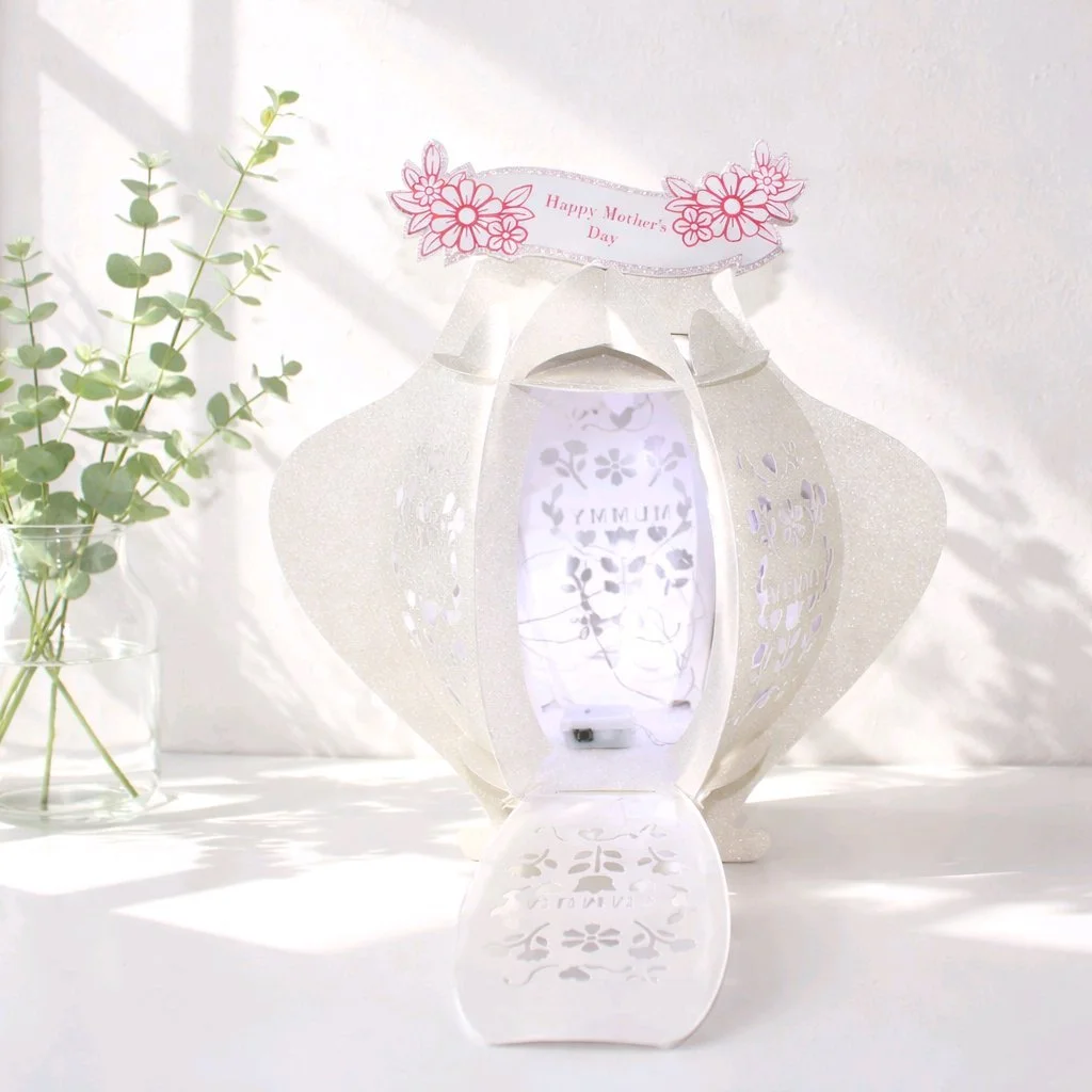 (NEW) Mother's Day Lantern! 
Each panel features delicate floral cut-outs and the word “MUMMY” elegantly die-cut into the sides, with clear acetate windows behind the designs to create a soft, glowing effect. Supplied with a safe, battery-operated LE