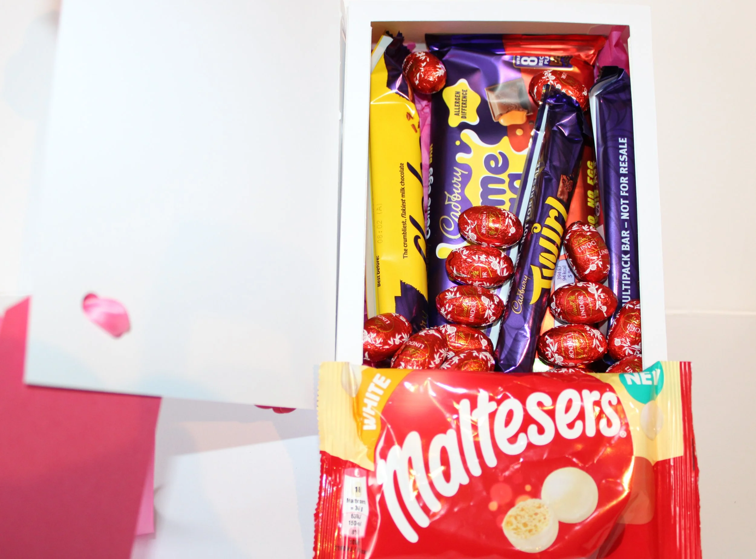 Handcrafted pink paper roses attached to the corners of the cover; each rose is hand-rolled for a natural look. A paper bow in matching pink is affixed in the top left corner for an elegant, layered detail. The interior is lined with soft pink tissue