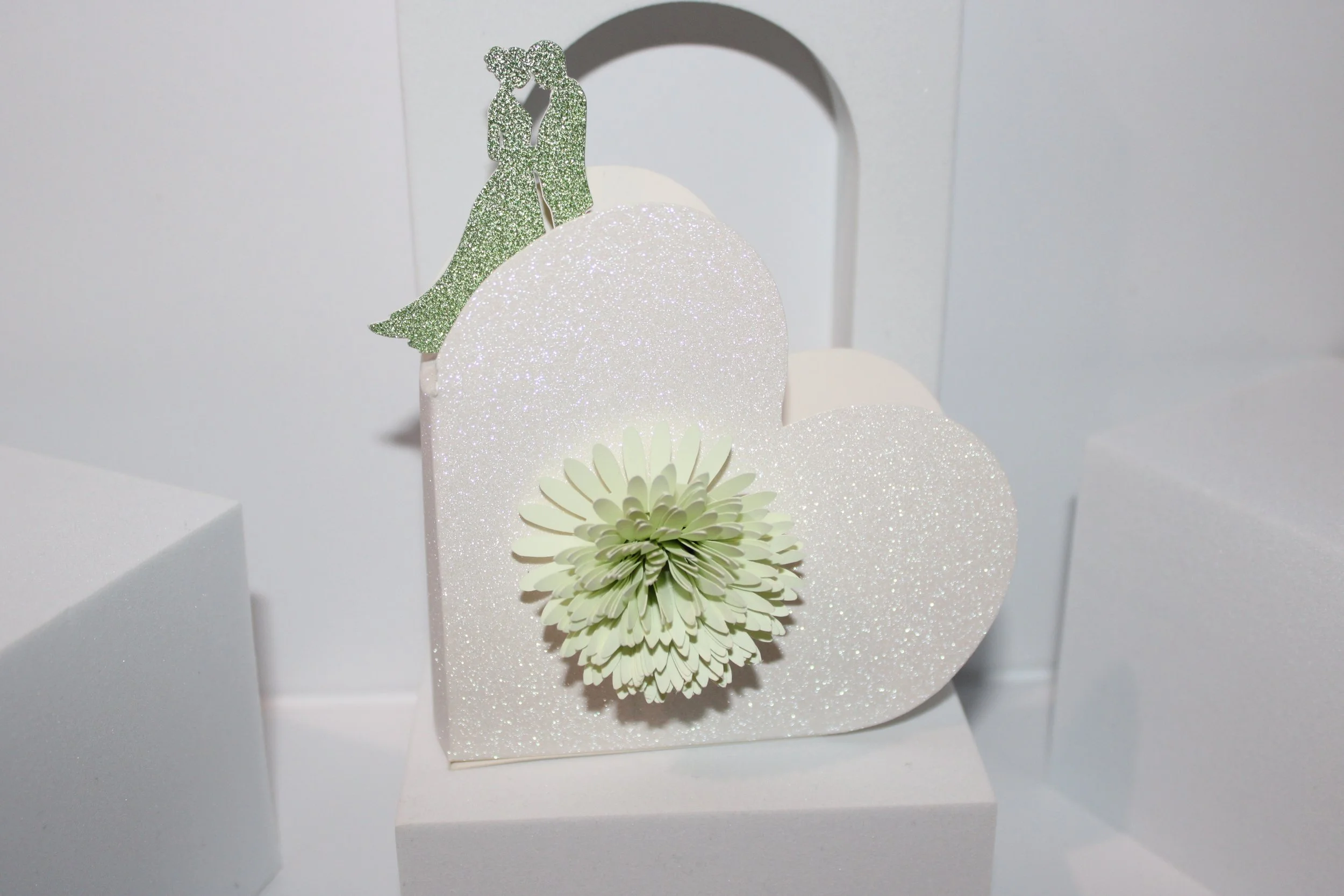 Heart box with silhouette couple & flower!
These stunning boxes are crafted with a sage green glitter card silhouette on the side—how romantic is that? #0071

