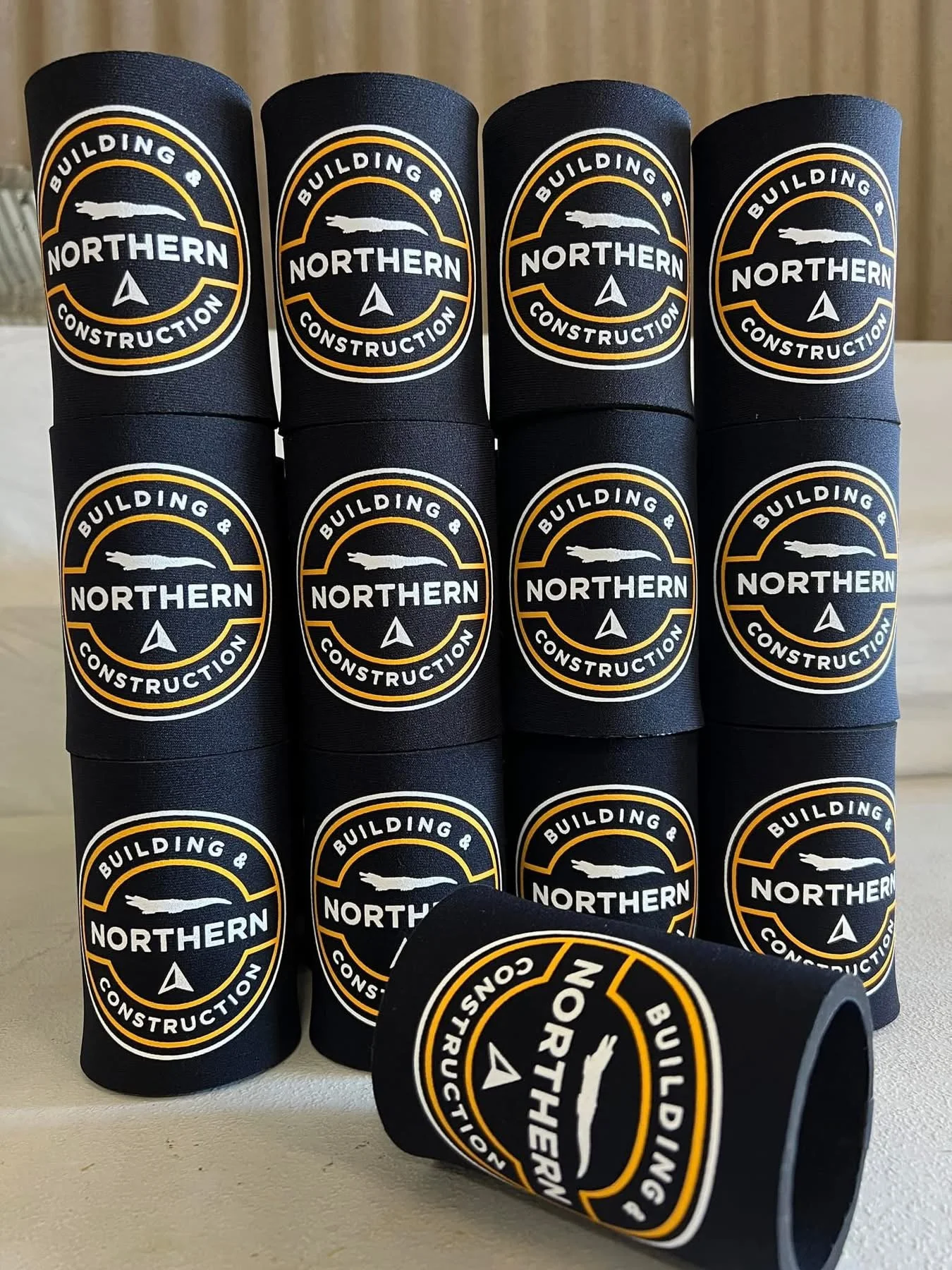 Stack of black silicone wristbands displaying the logo and text for Northern Building & Construction.