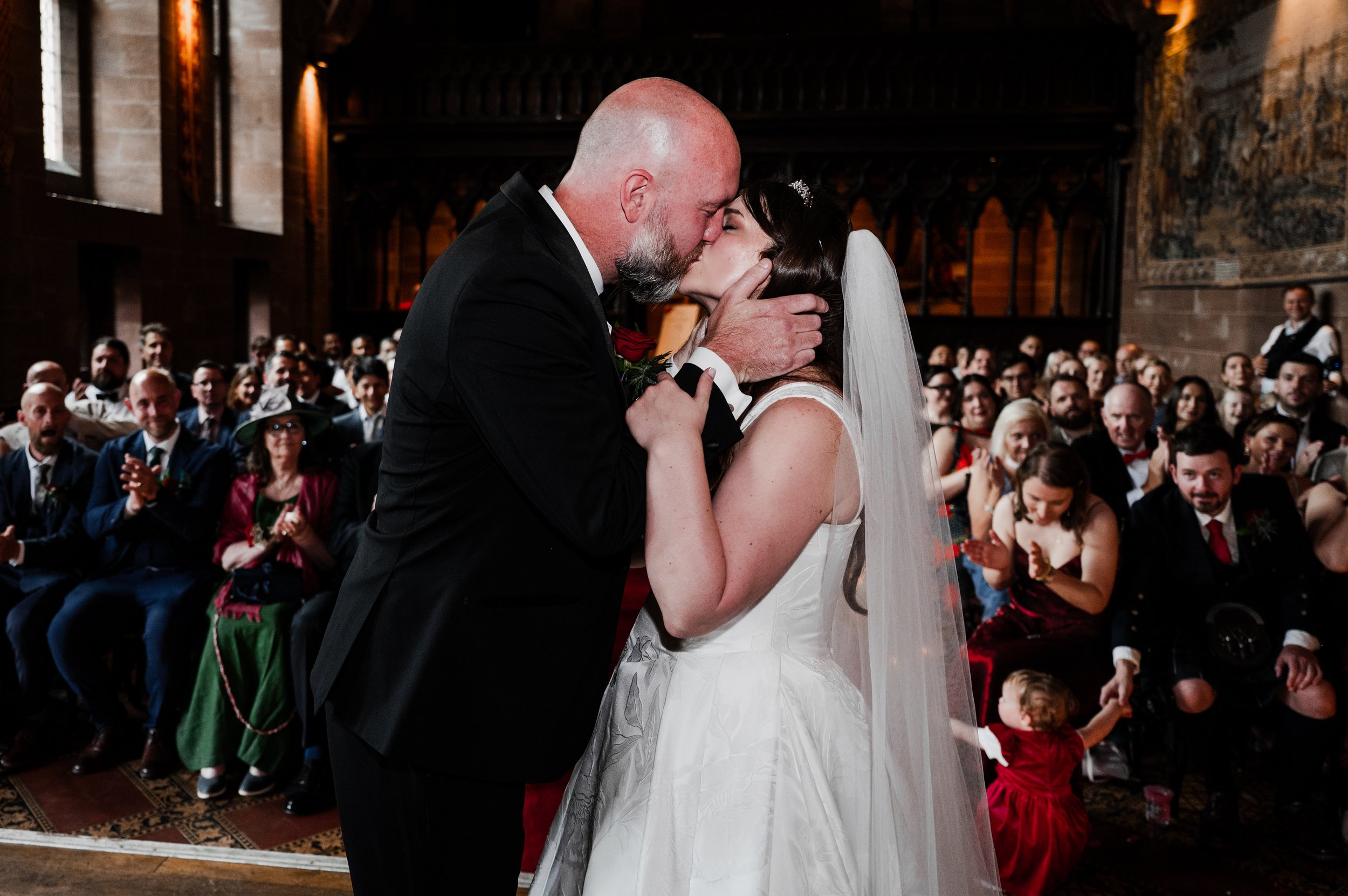 Peckforton Castle - bride and groom in wedding attire kissing after exchanging wedding vows