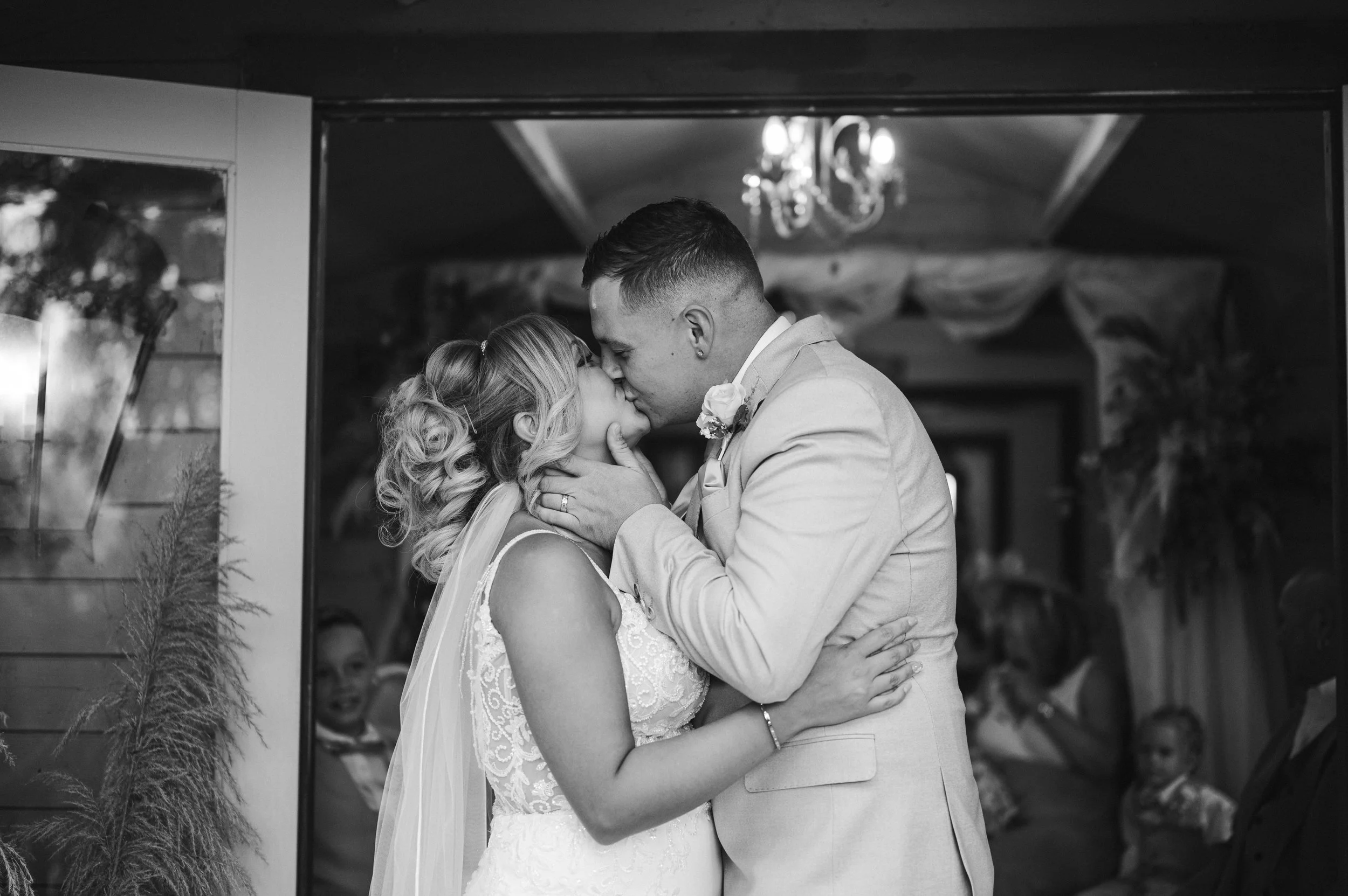 The Love Shack - Black and white image of groom and bride in wedding attire, kissing