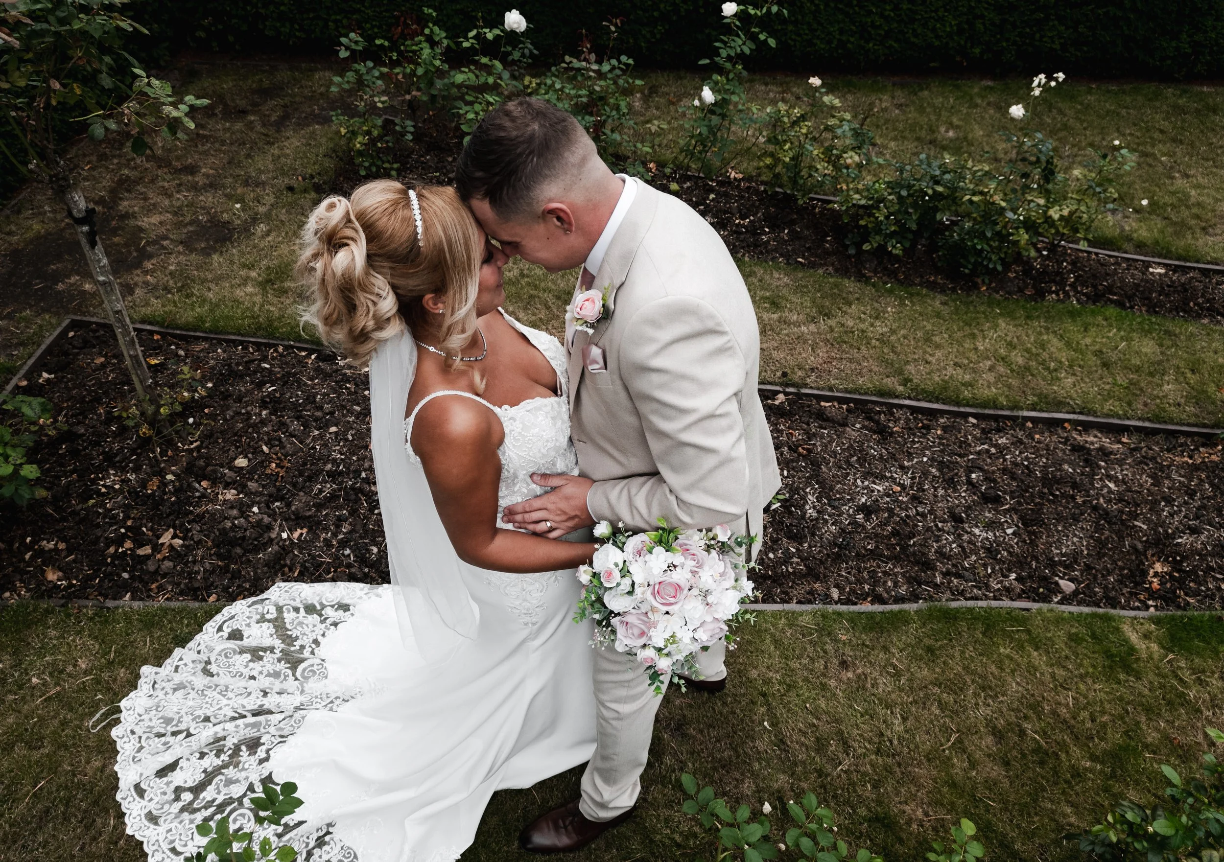The Love Shack - Drone image of groom and bride in wedding attire, stood facing each other. 