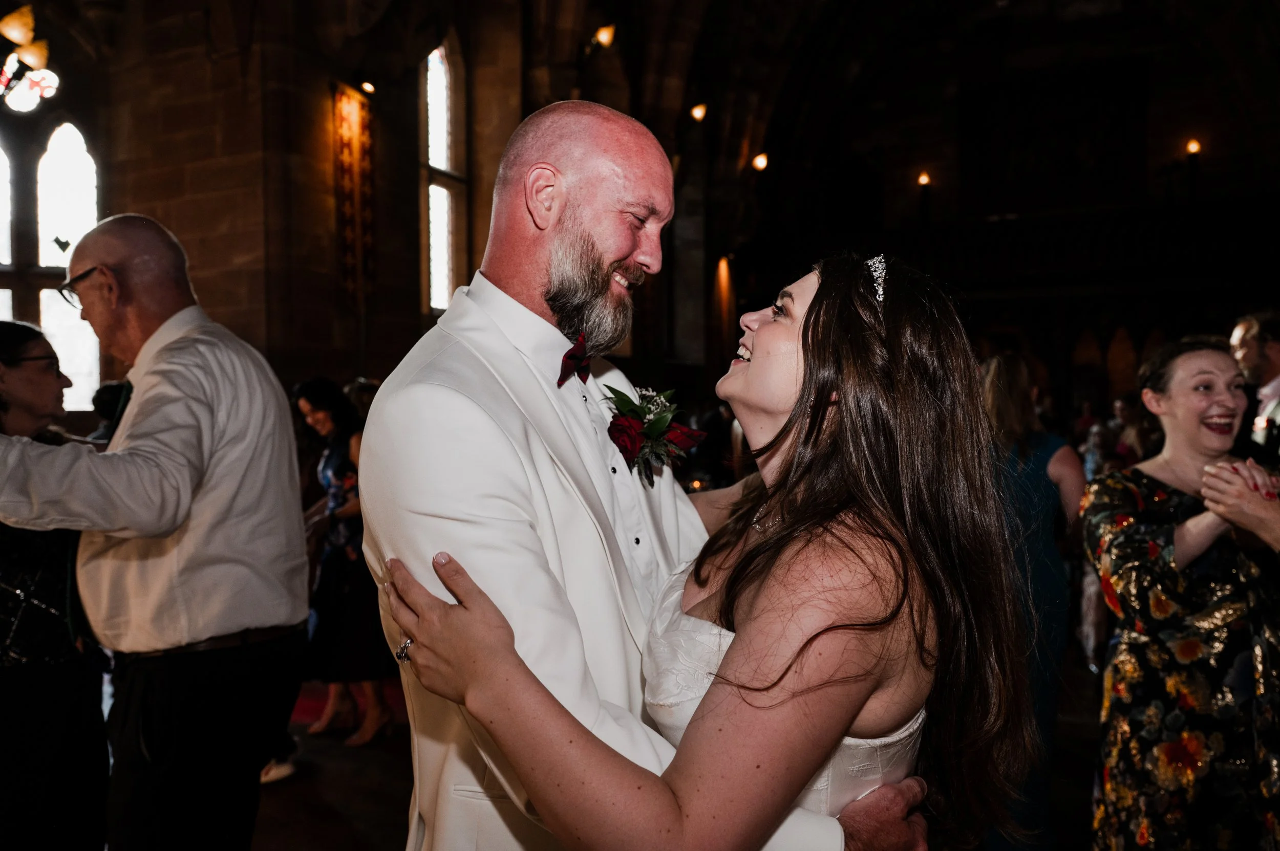 Peckforton Castle - bride and groom in wedding attire in an embrace, dancing and smiling together. 