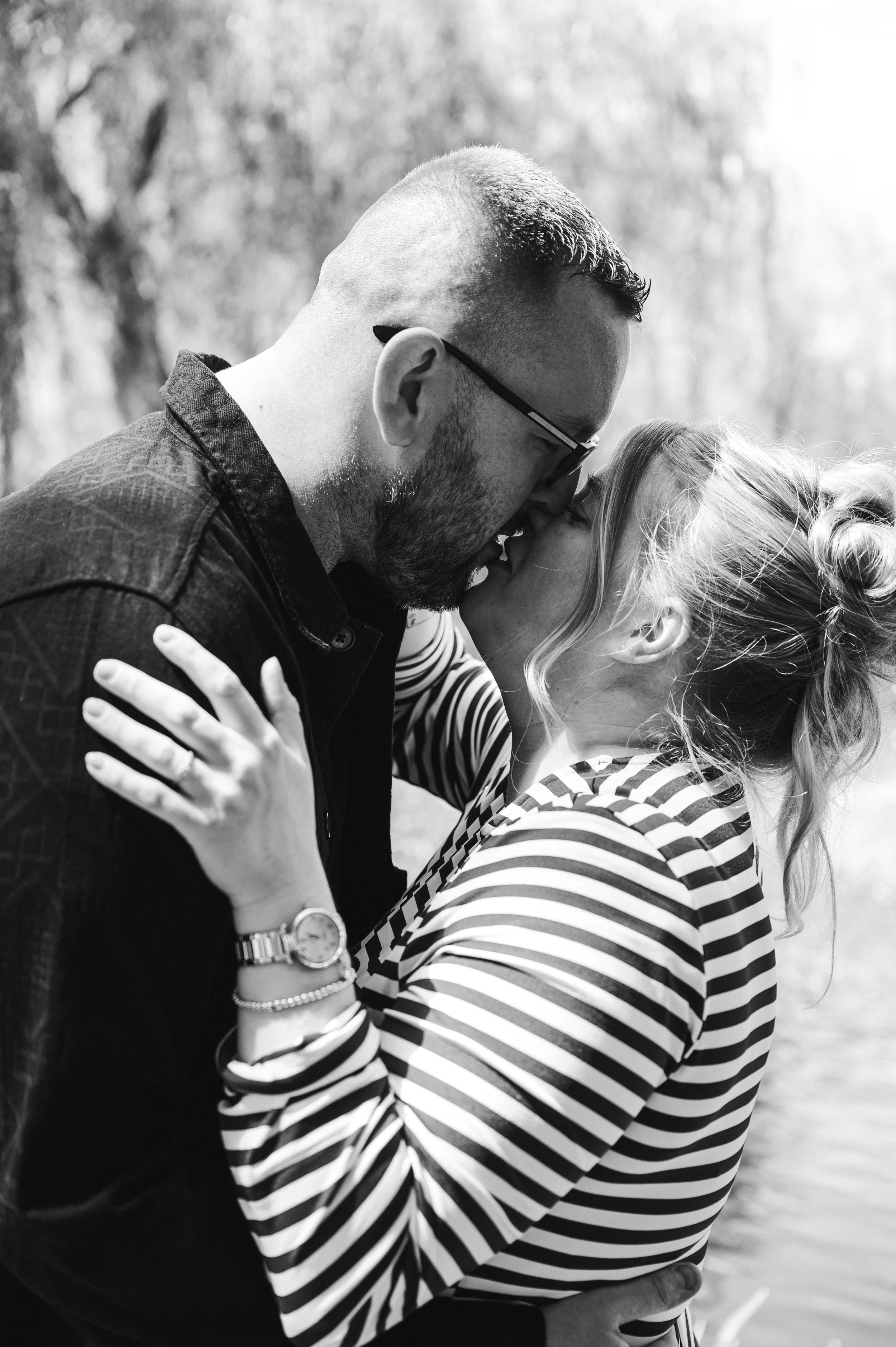 The Grosvenor Pulford Engagement - black and white image of man in black shirt and woman in striped top, embracing and kissing