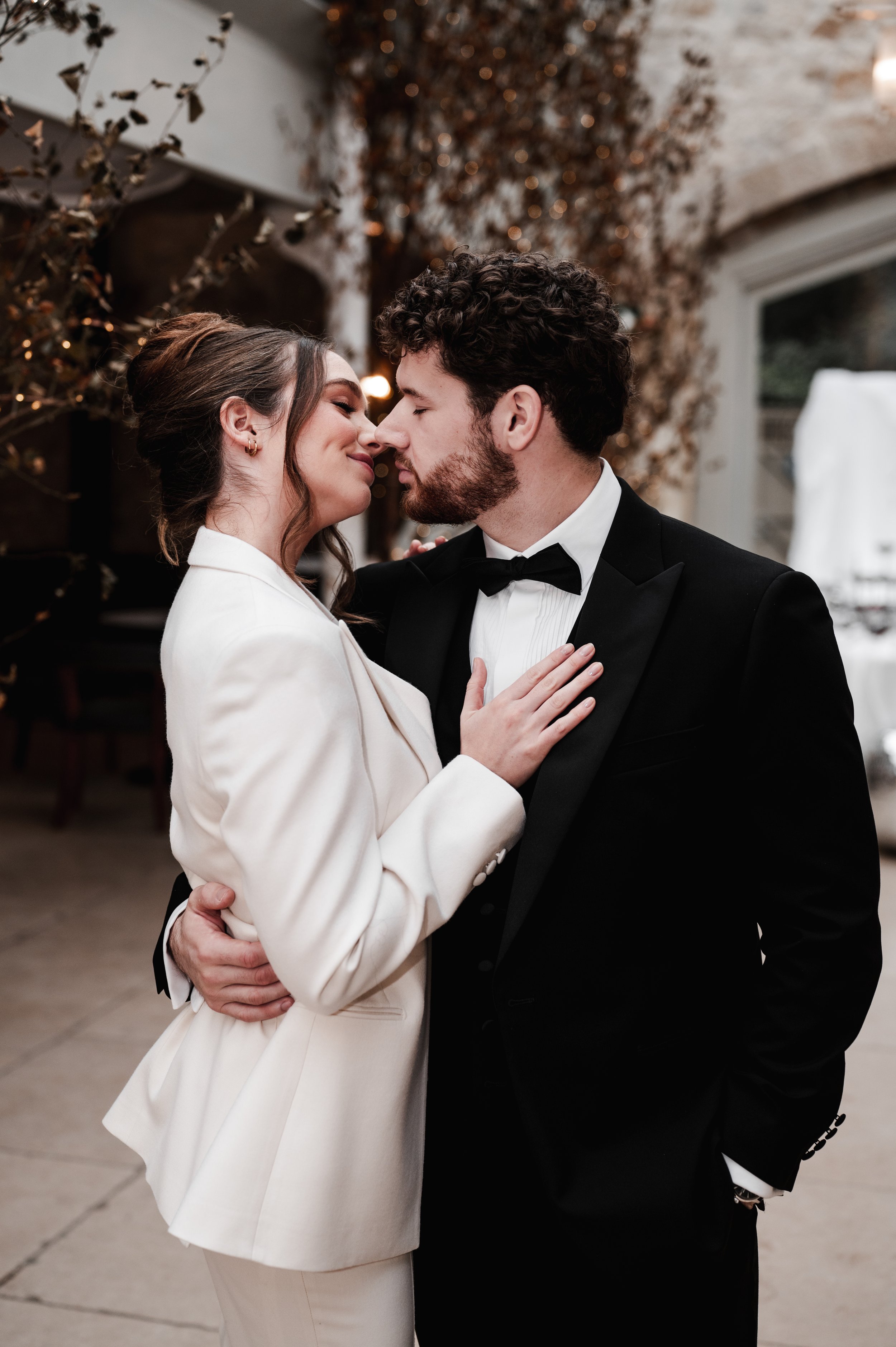 Bride and groom in matching tailored suits in embrace