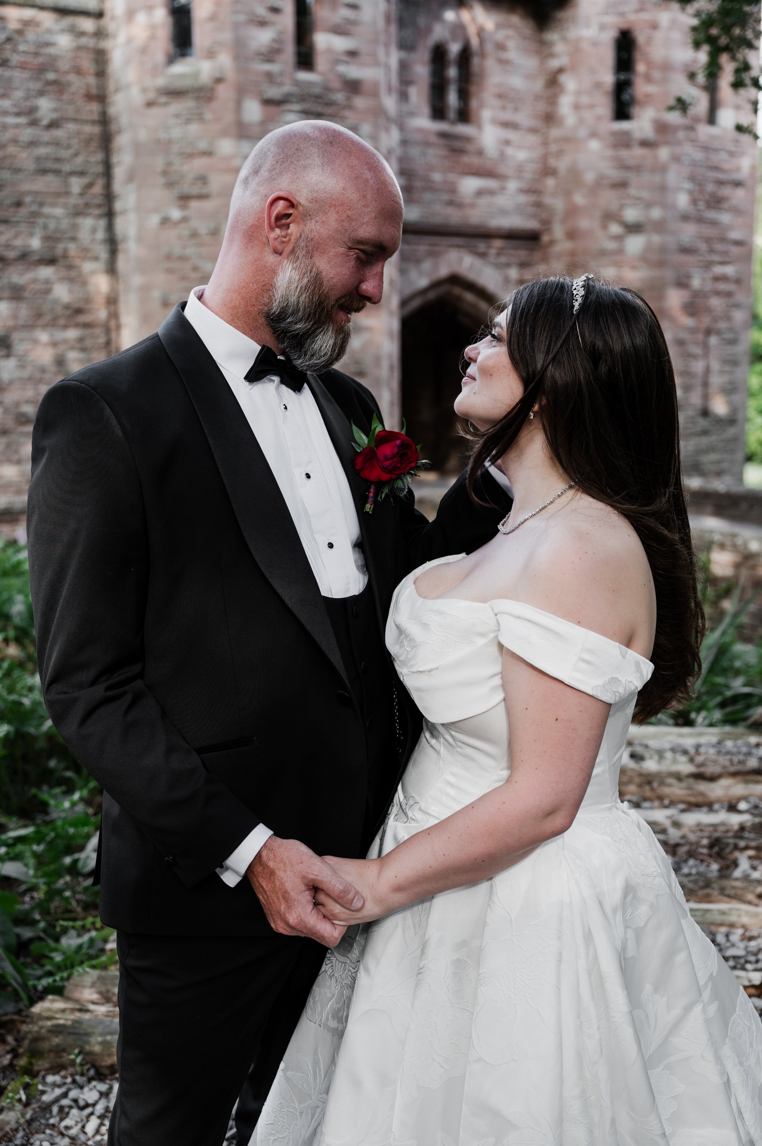 Peckforton Castle - bride and groom in wedding attire holding hands