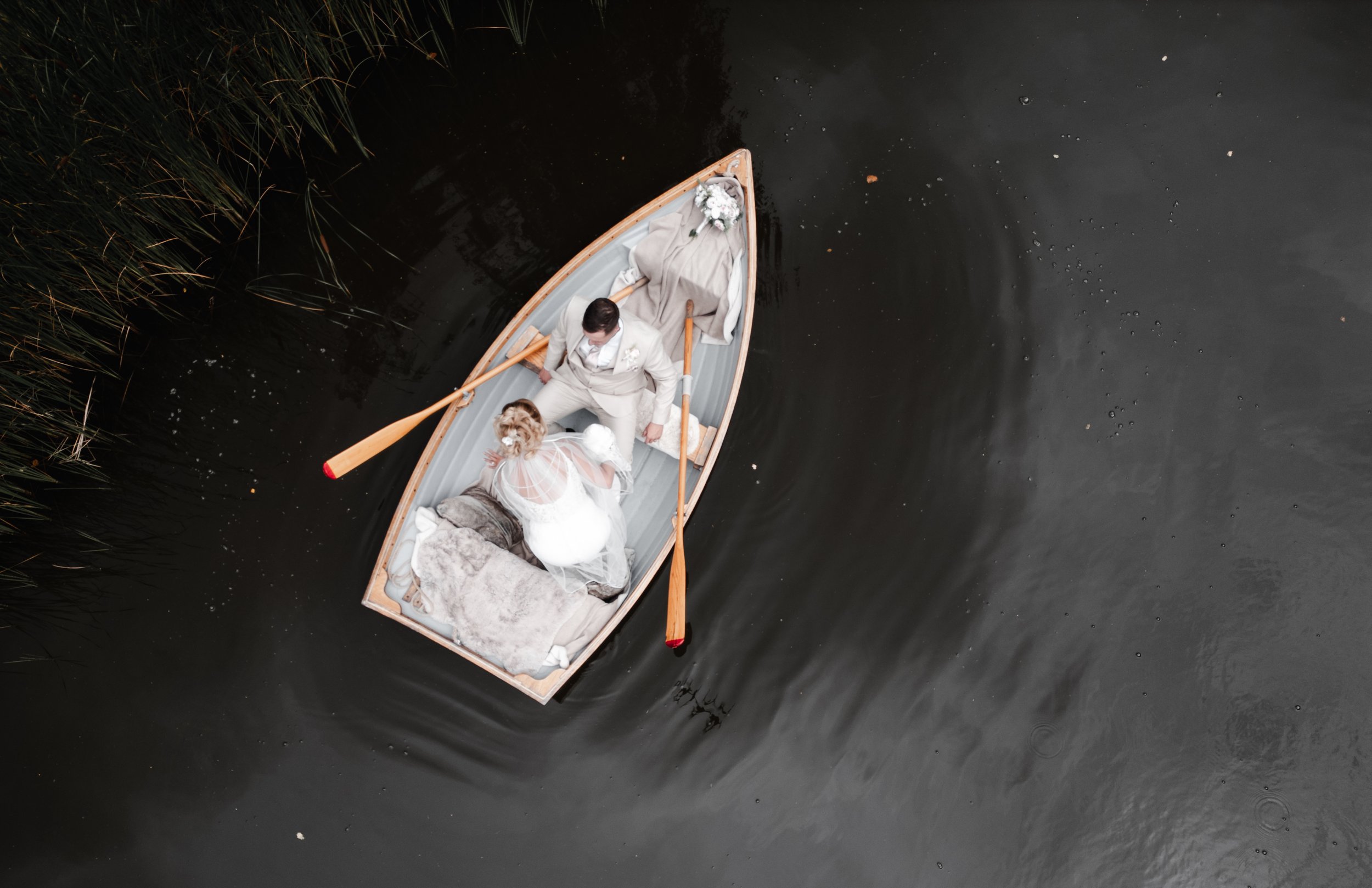 The Love Shack - groom and bride in wedding attire being pictured from above in a small boat