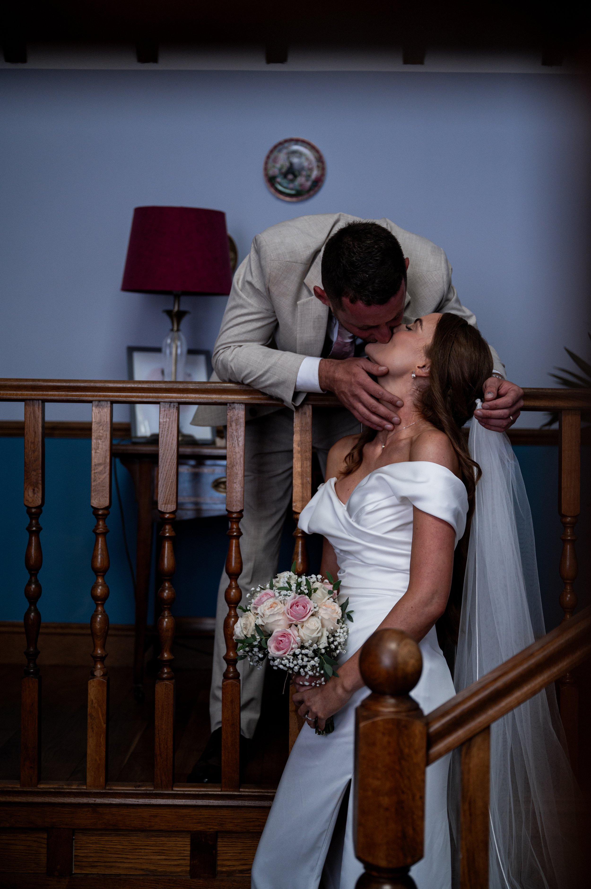 All Saint Church - Bride and groom in wedding attire stood on stairs and kissing