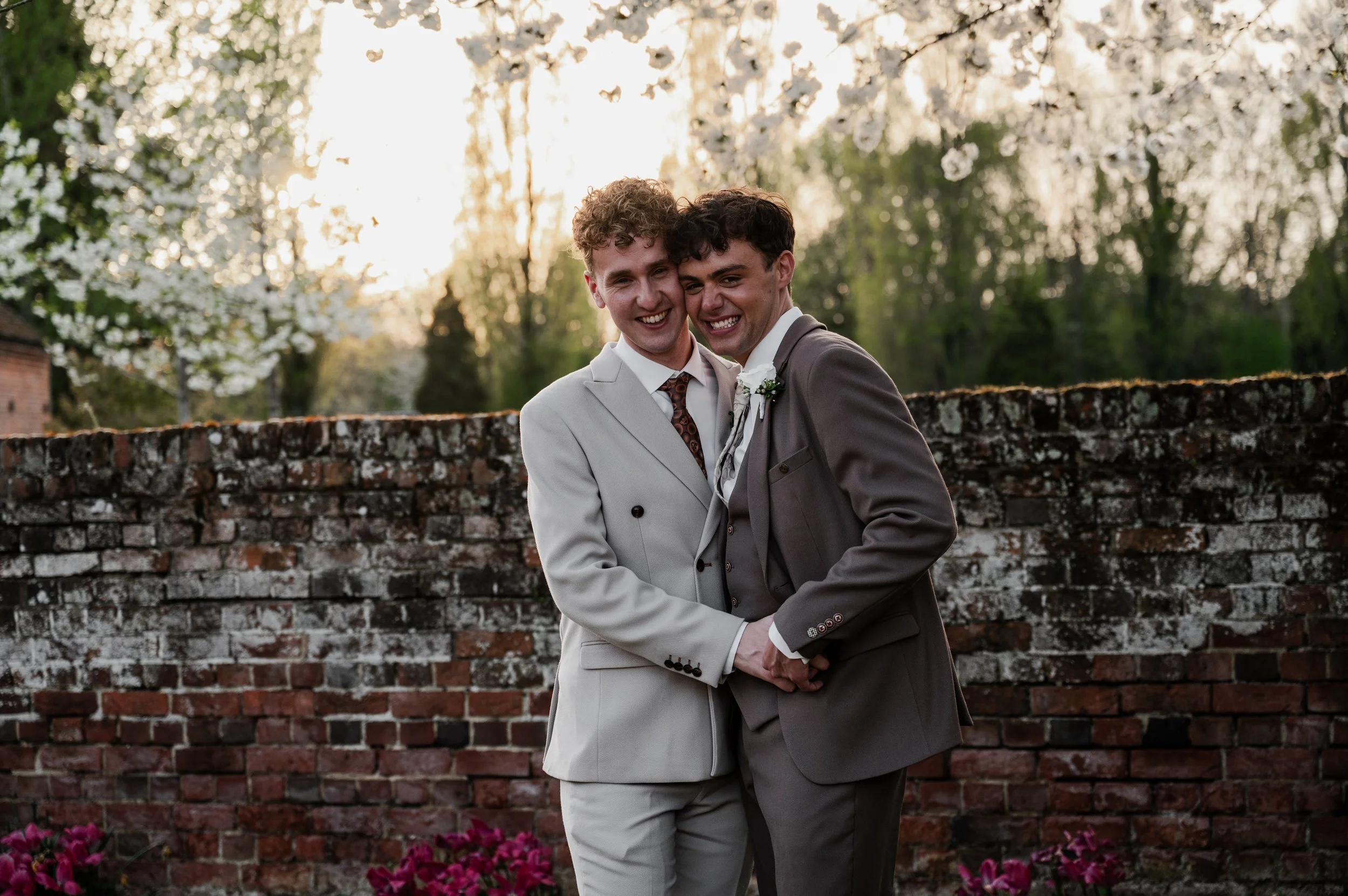 Two grooms in a close embrace and smiling