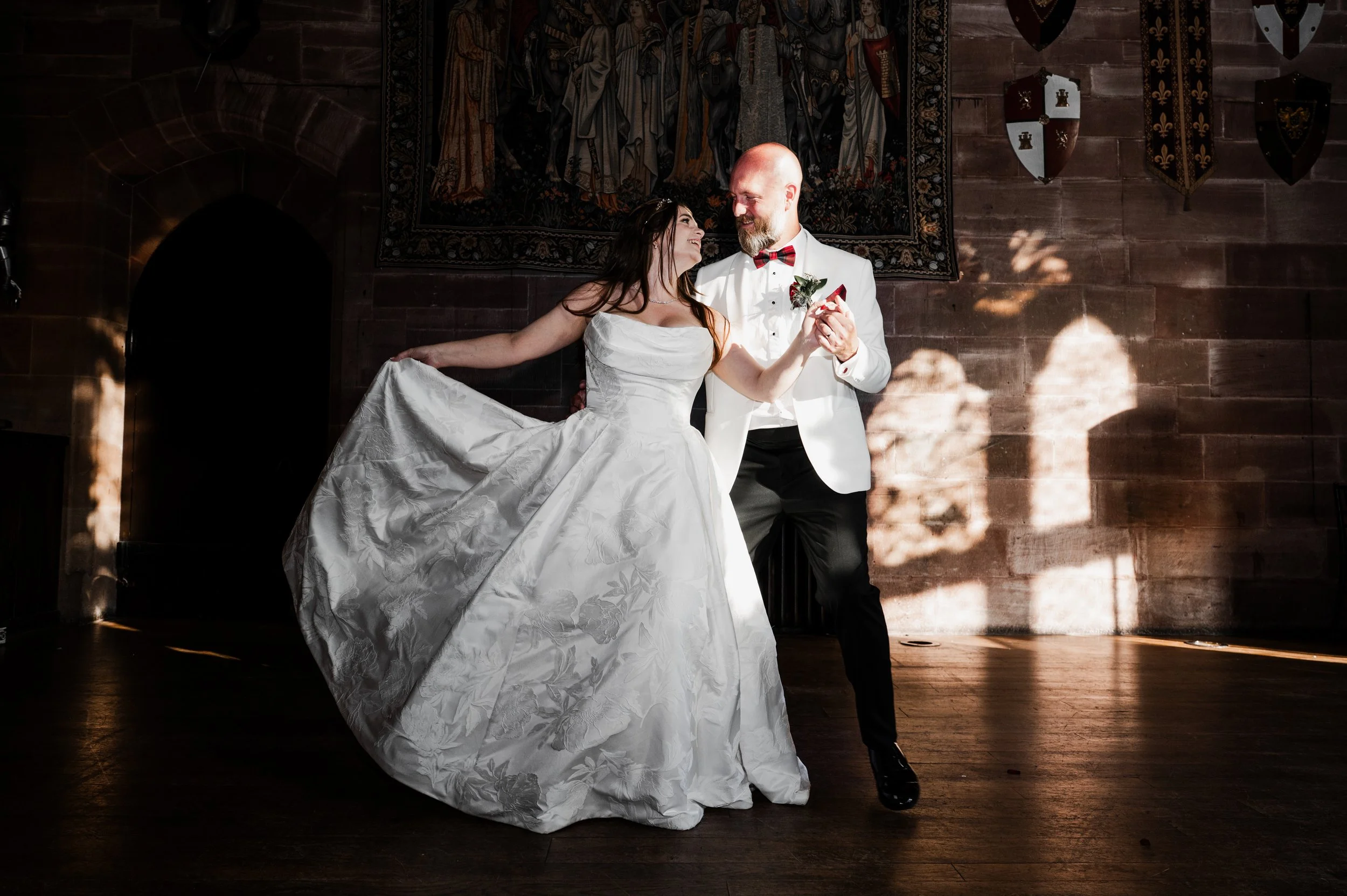 Peckforton Castle - bride and groom in wedding attire dancing together in a hall