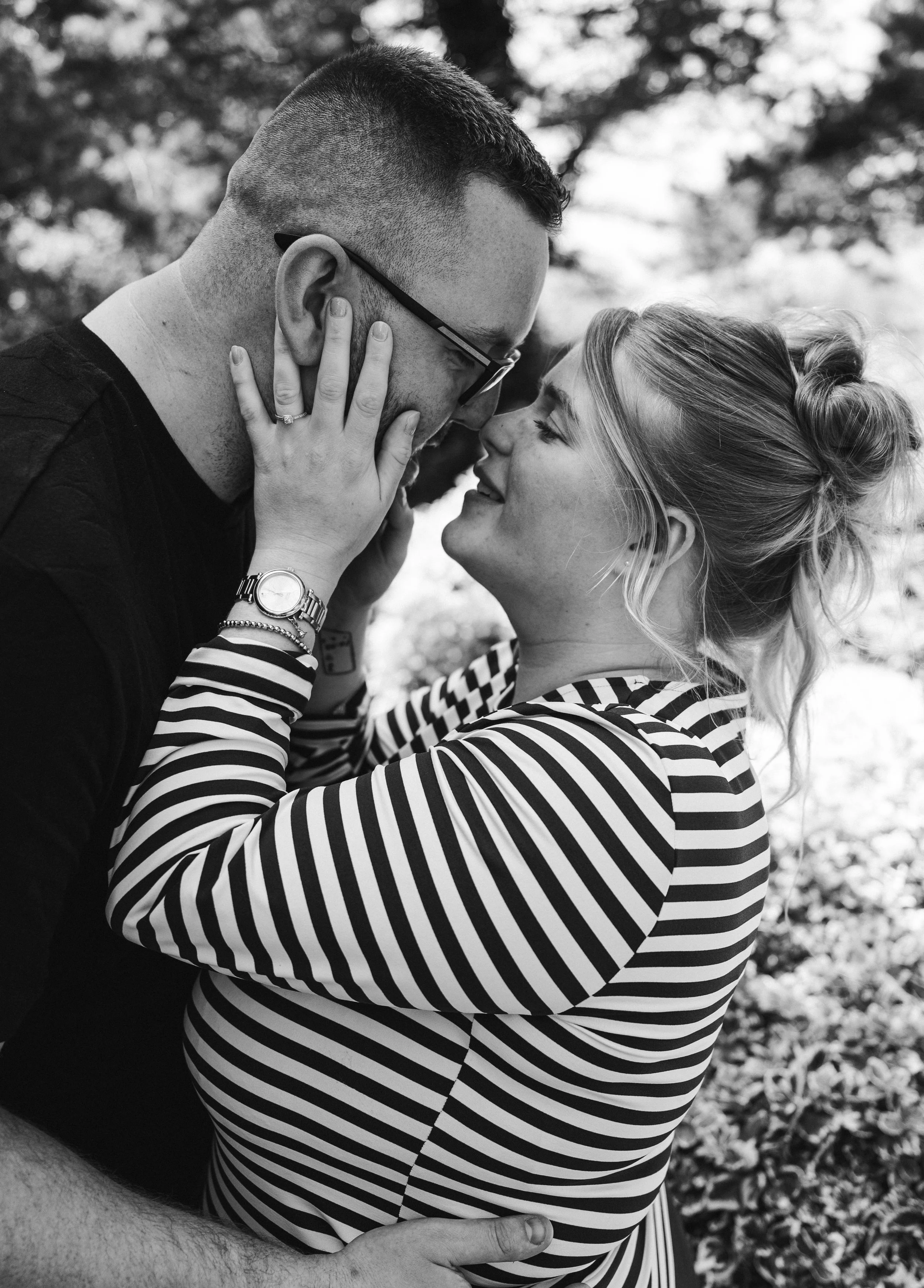 The Grosvenor Pulford Engagement - black and white image of man in black shirt and woman in striped top, embracing and about to kiss