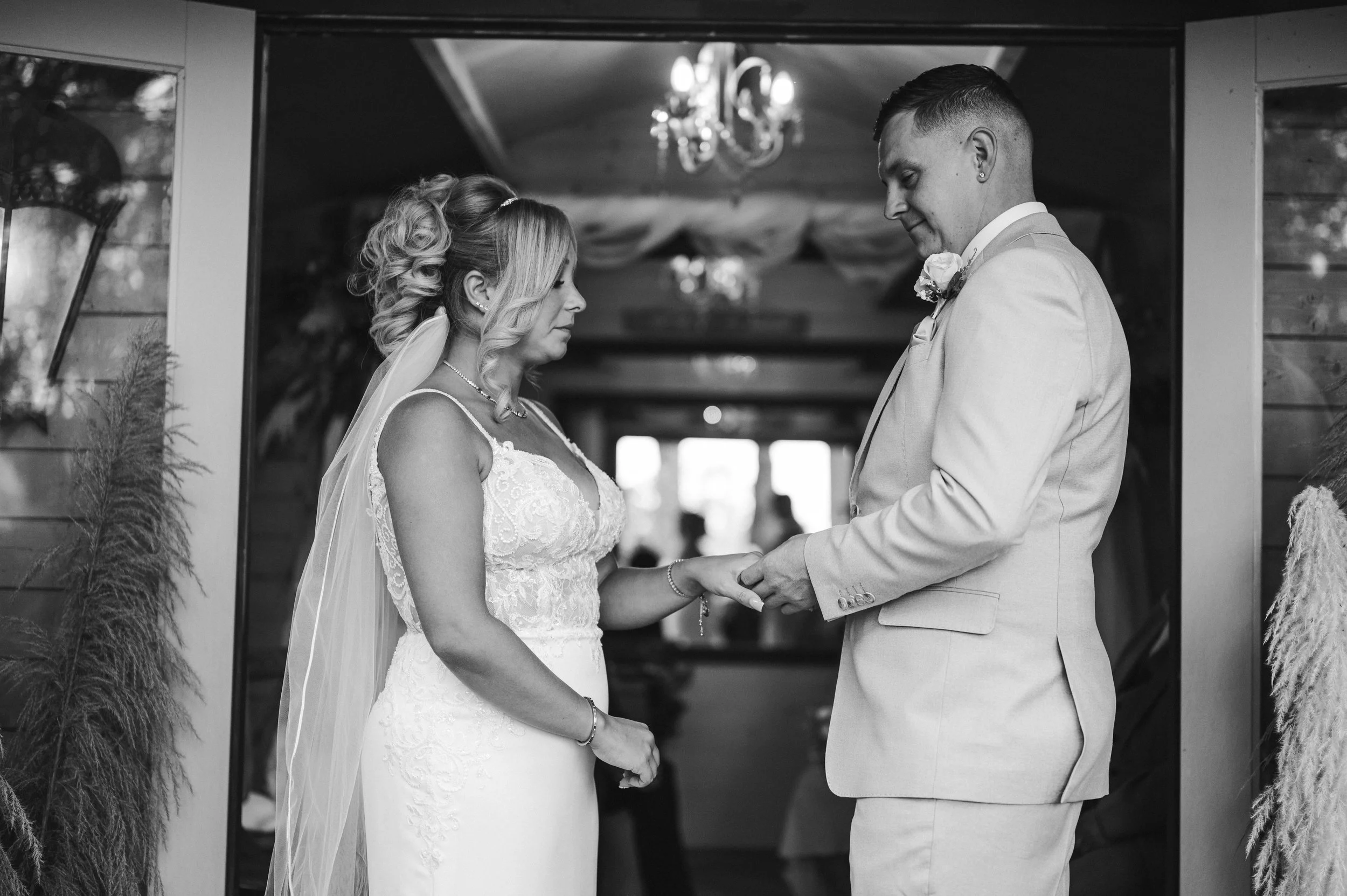 The Love Shack - black and white image of groom and bride in wedding attire, facing each other during a ceremony. 