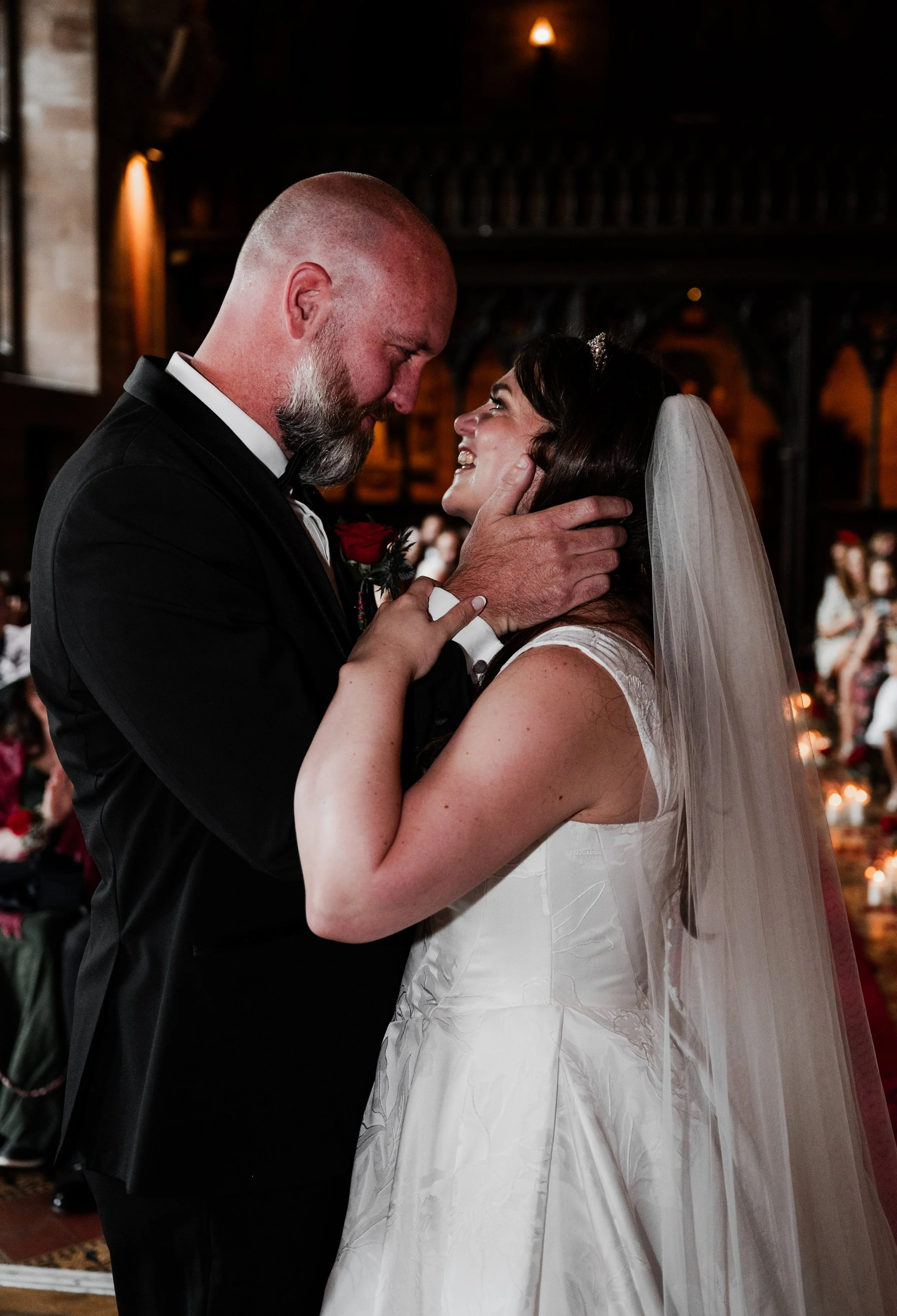 Peckforton Castle - bride and groom in wedding smiling at each other after kissing at the end of wedding ceremony