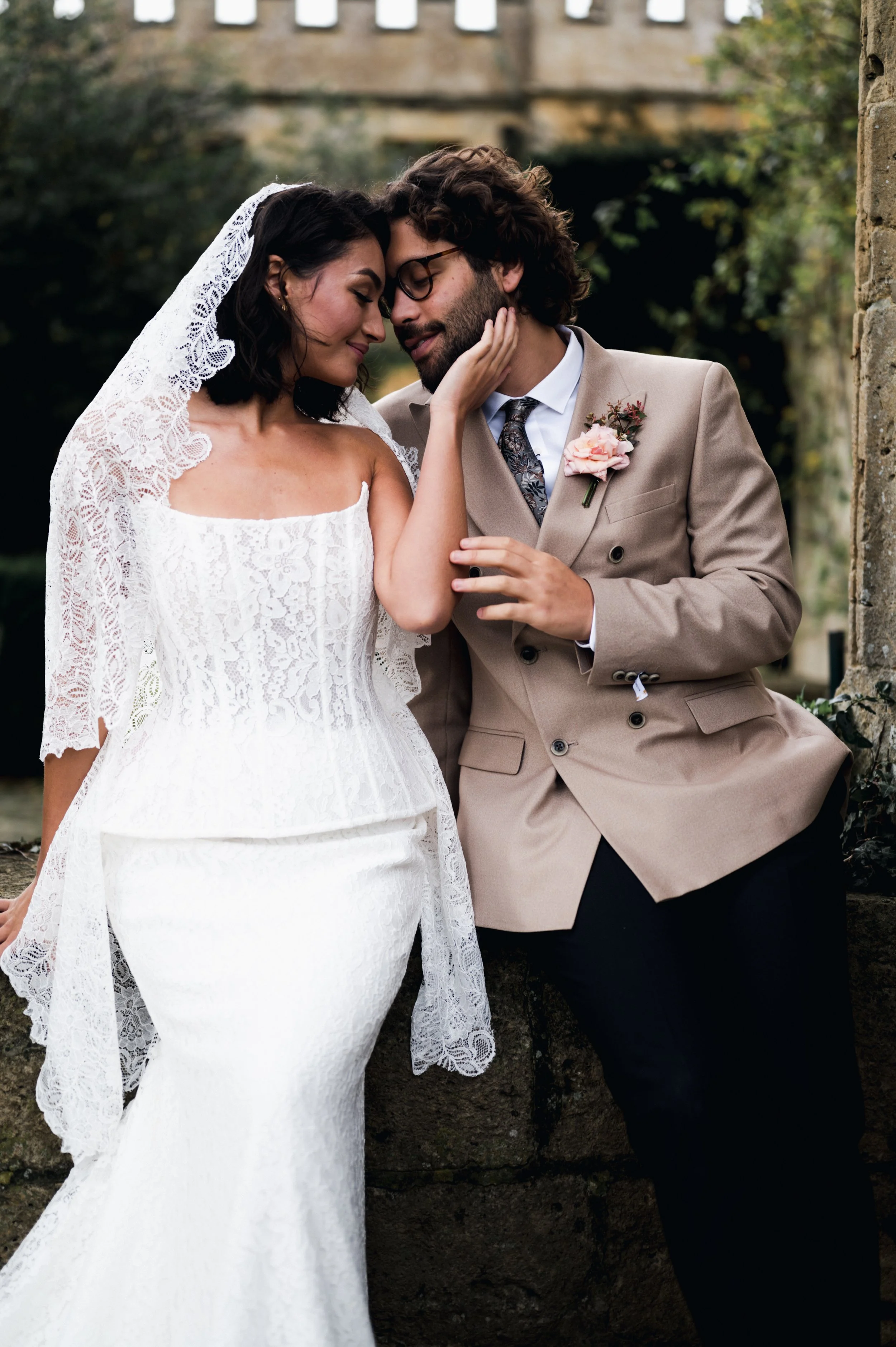 Bride and groom in wedding attire, staring lovingly 