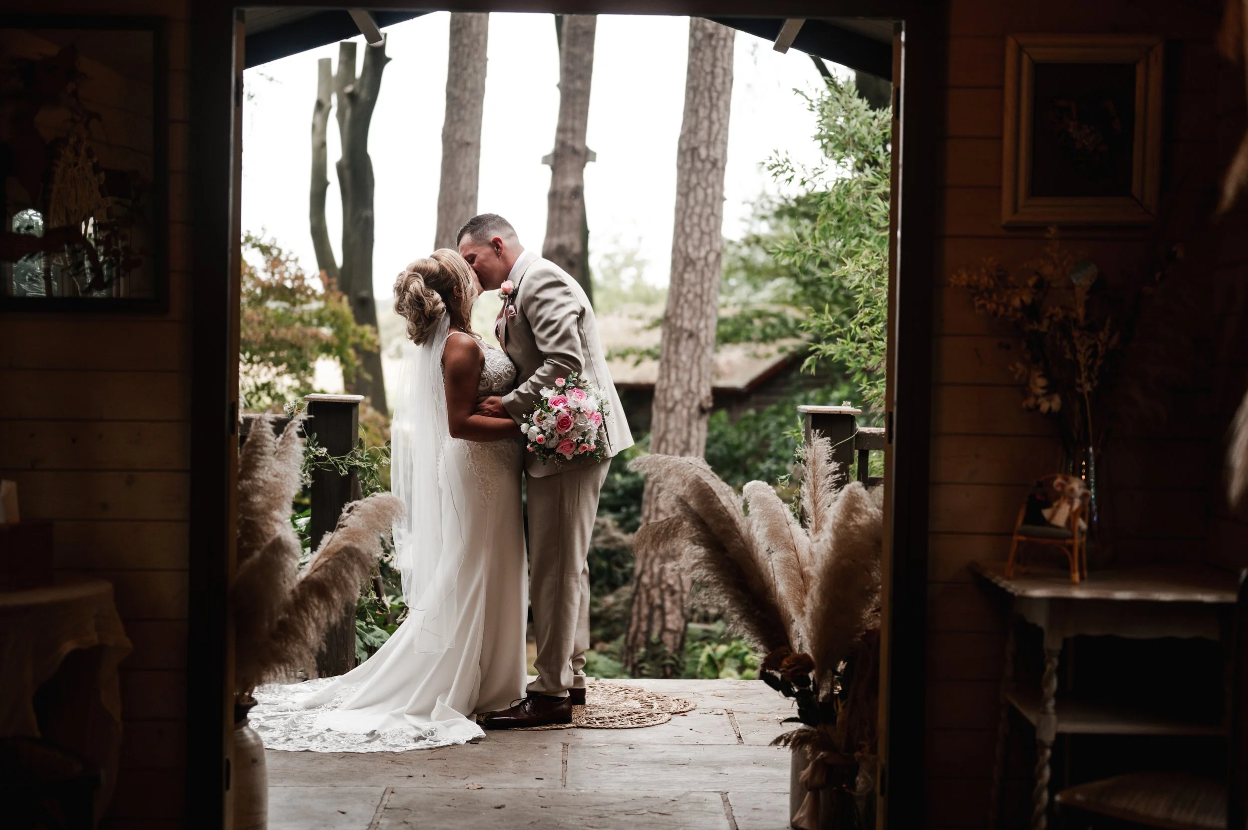 The Love Shack - Groom and bride in wedding attire, kissing at the end of a ceremony. 