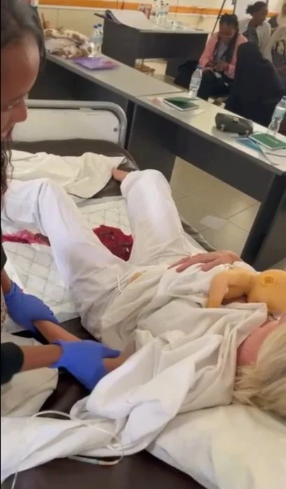 En person som får en medicinsk behandling, möjligen en graviditetskontroll, i ett kliniskt rum.
