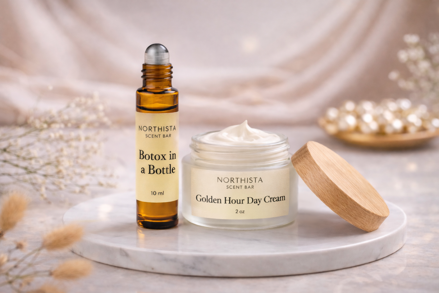 Beauty products, including a small bottle labeled 'Botox in a Bottle' and a jar labeled 'Golden Hour Day Cream,' placed on a white marble surface with a lid nearby, surrounded by decorative dried flowers and a blurred tray of small pearls in the background.
