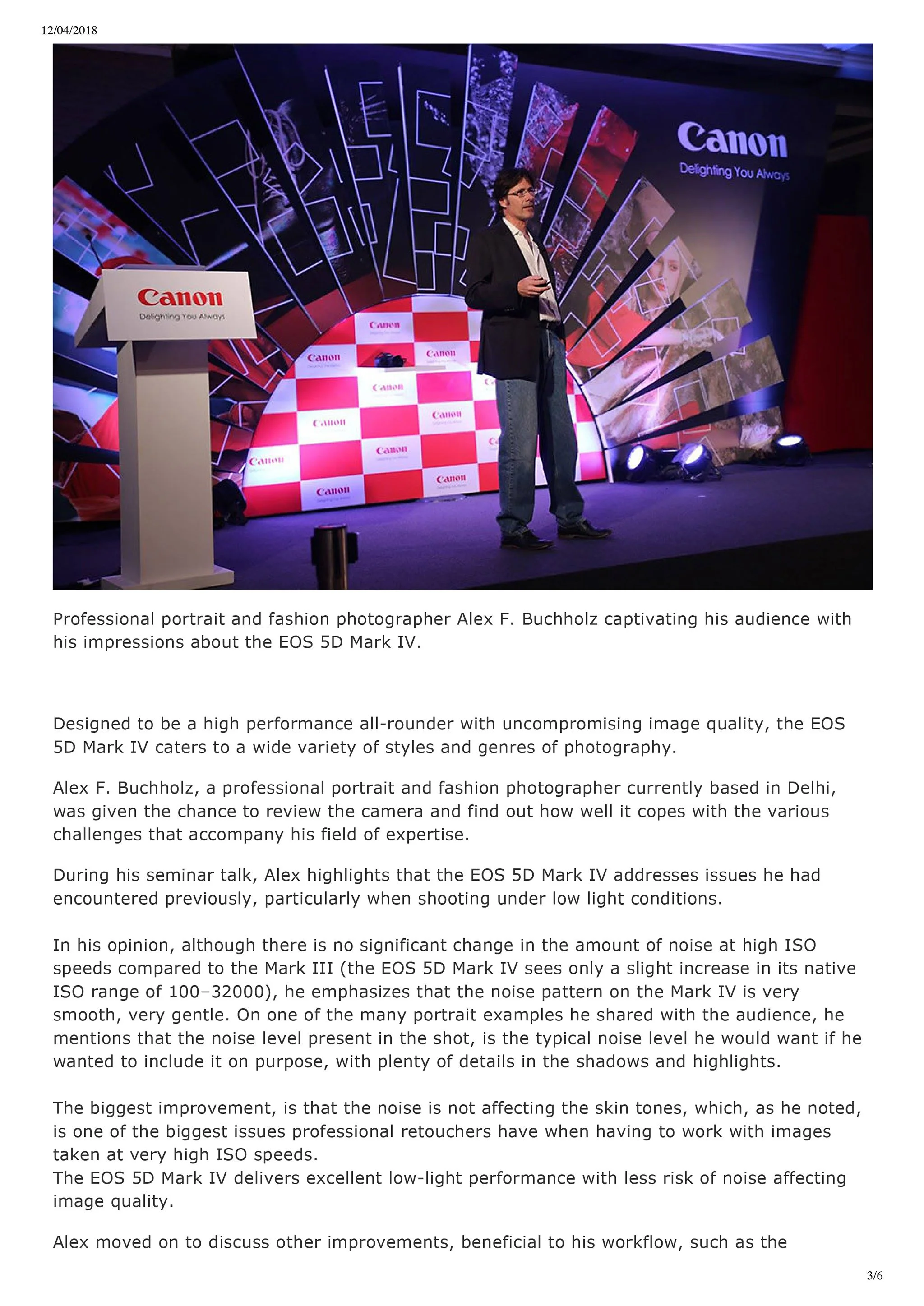 Photograph of a professional portrait and fashion photographer, Alex F. Buchholz, speaking at a Canon event on stage with a backdrop of colorful abstract graphics and a Canon logo, holding a microphone, dressed in a blazer and jeans.