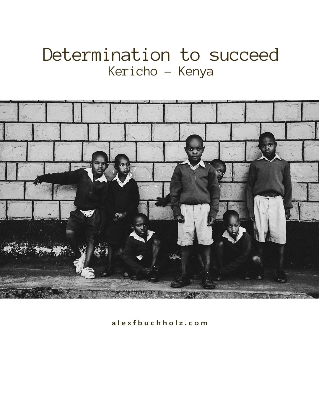 Children standing and sitting against a brick wall in Kenya, black and white photo.