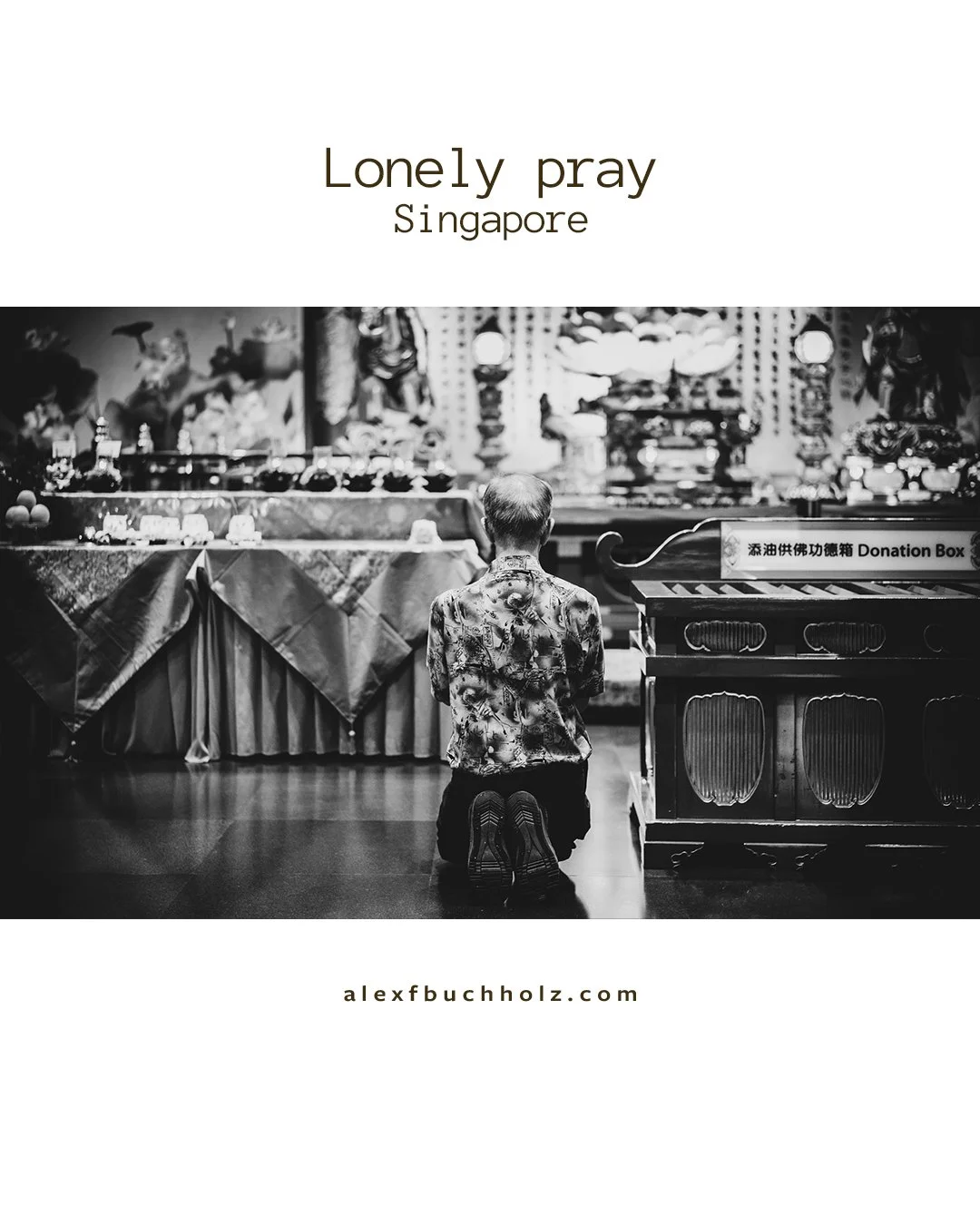 A person kneeling in front of an altar or shrine with offerings in Singapore, in black and white.