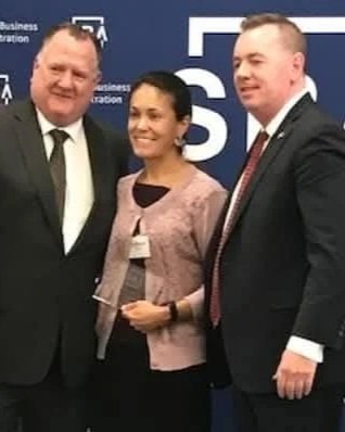 Two men and a woman pose for a photo