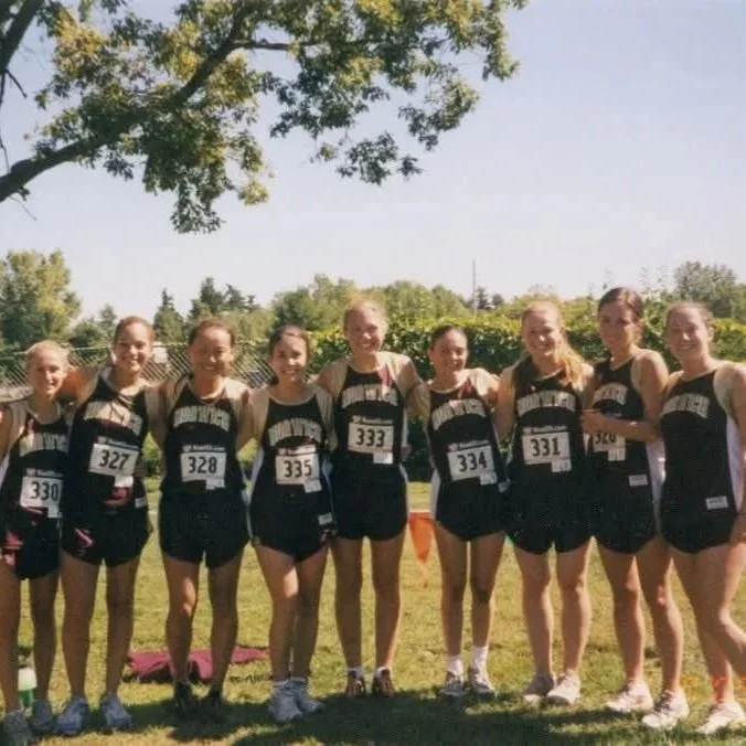 Group of nine women wear Norwich University running uniforms