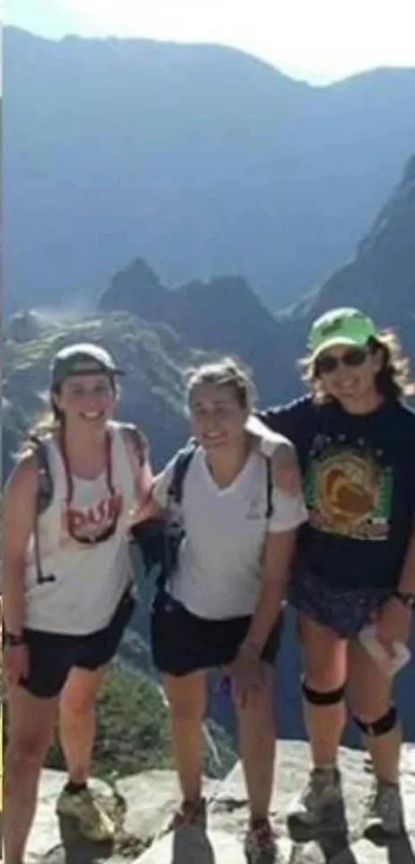 Three women pose for a photo during a hike