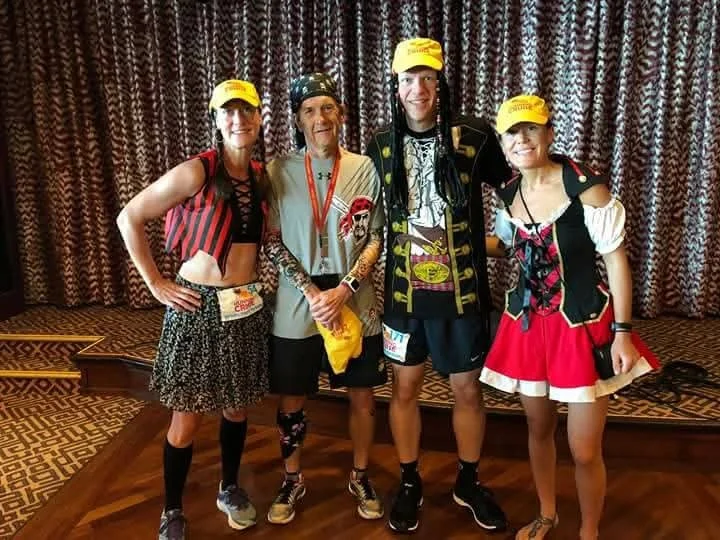 Two men and two women dressed as pirates pose for a photo before a marathon