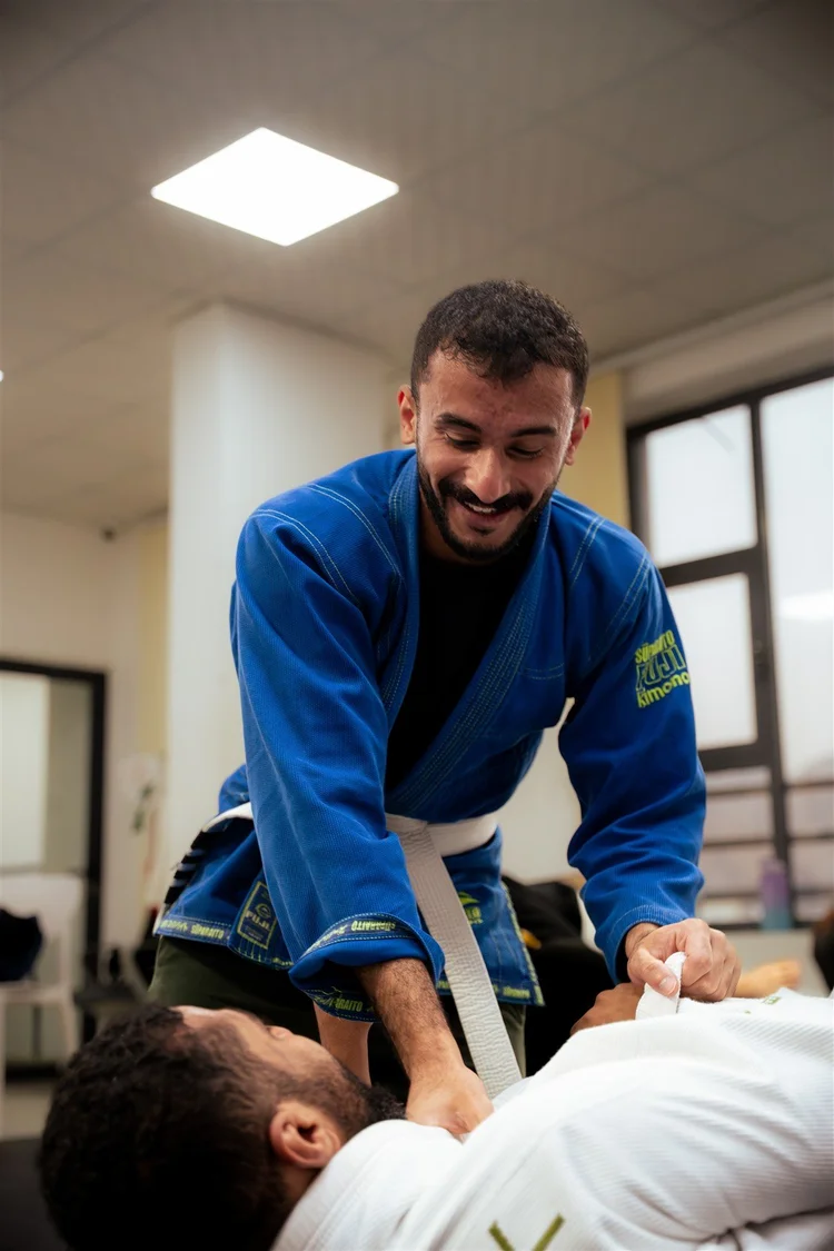A student smiling while practising Gi Brazilian Jiu-Jitsu at Fight Sports Muscat