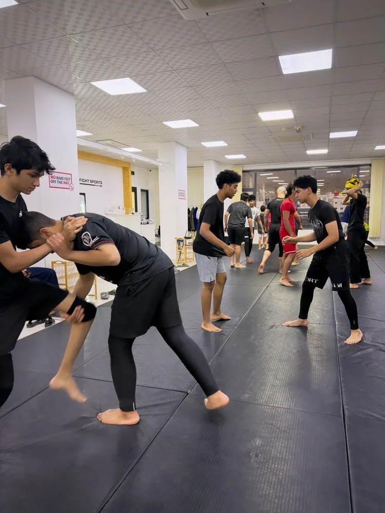 Teens practising standing grappling techniques at Fight Sports Muscat