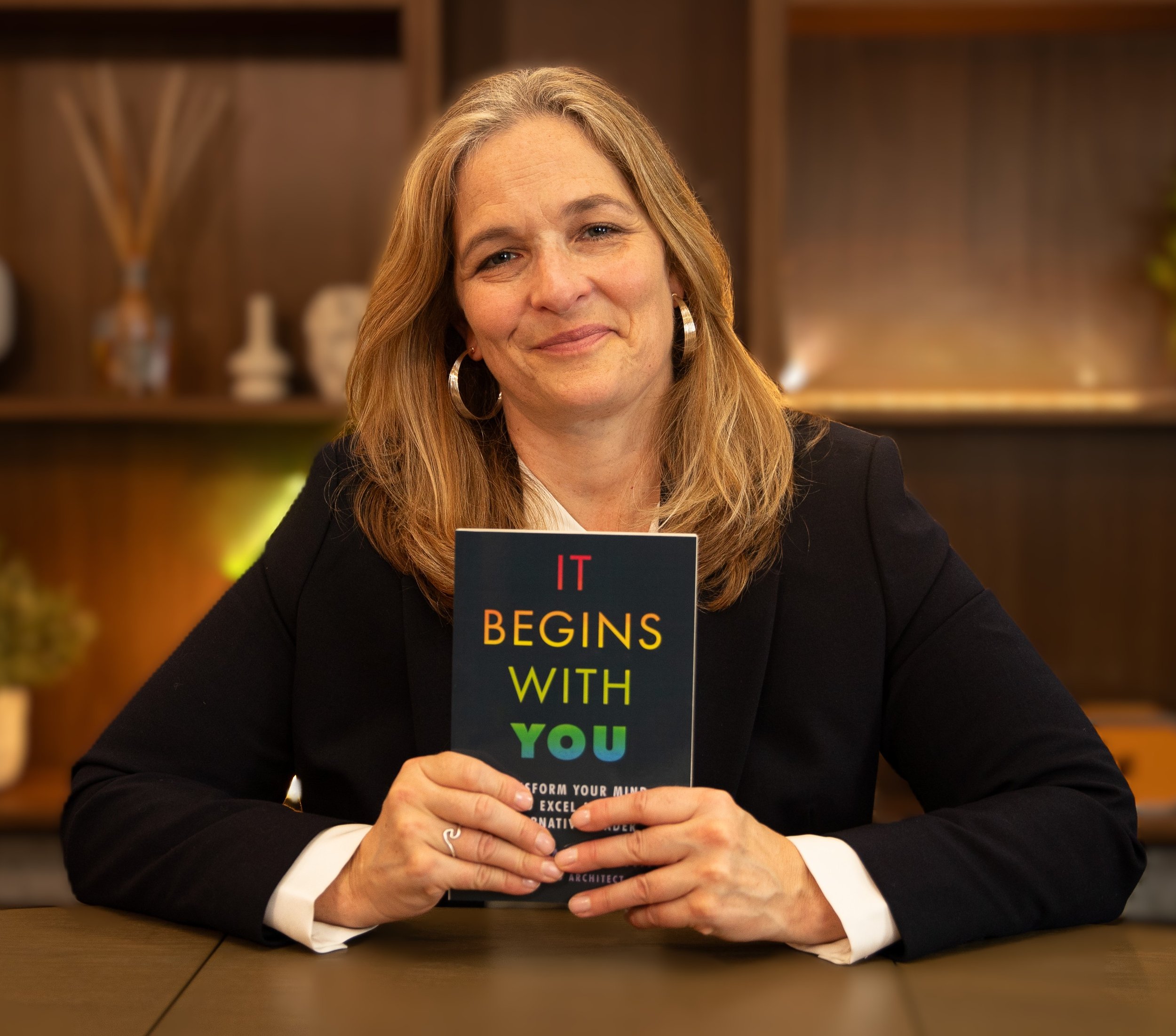 Mari Williams with her book, It begins with you, leadership coaching and executive therapy